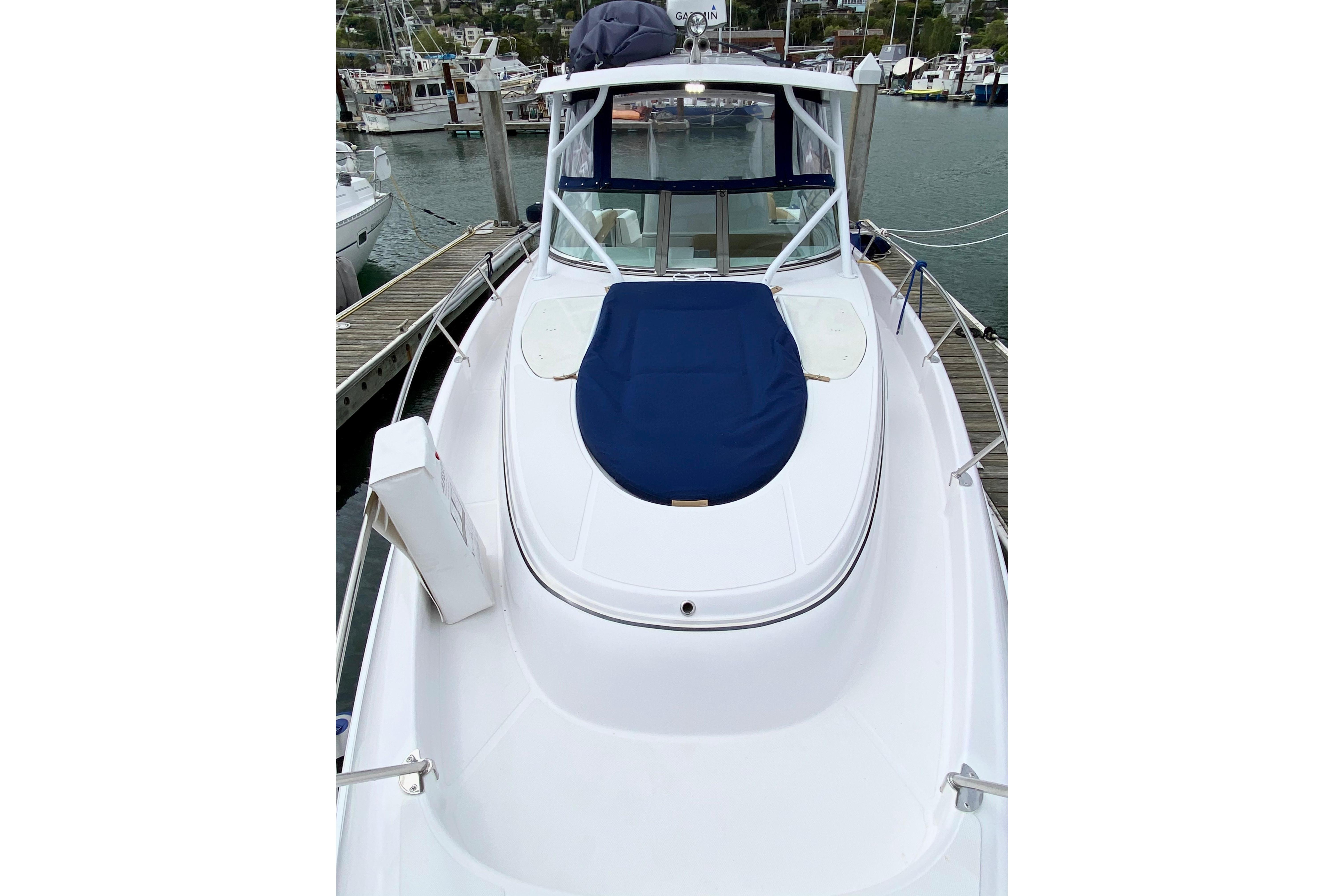 2006 Donzi 38 ZSF boat docked at marina, featuring sleek white design and blue cover.