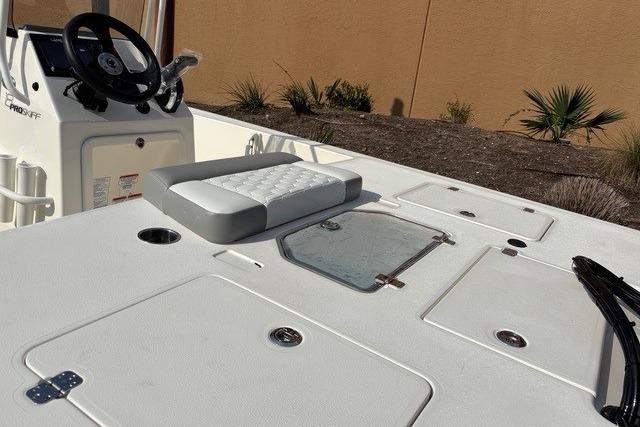 2026 Mako 18 Pro Skiff boat deck with steering wheel and storage compartments.