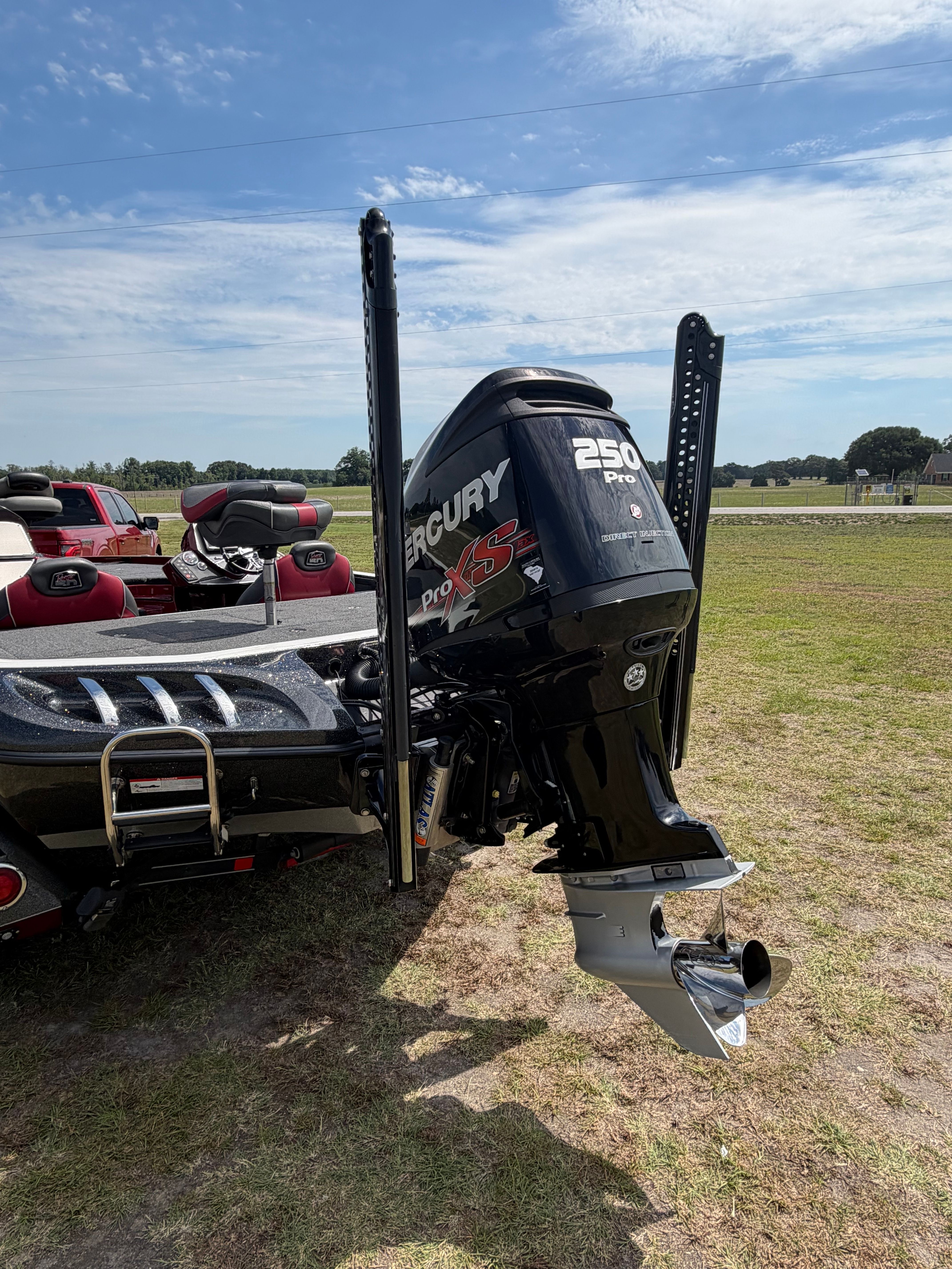 A Ranger 521C boat with a Mercury 250 HP outboard motor on a grassy field.