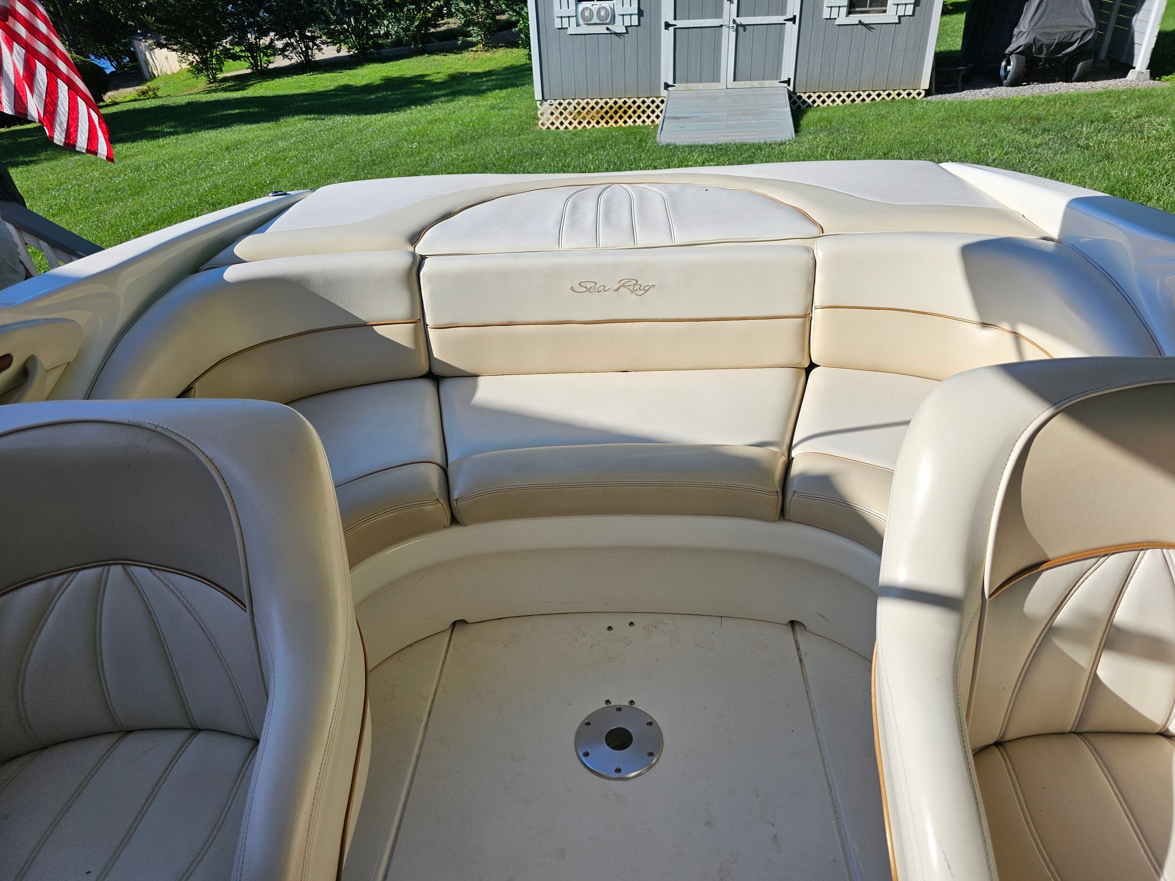 Interior view of a Sea Ray 230 Overnighter boat with beige leather seating.