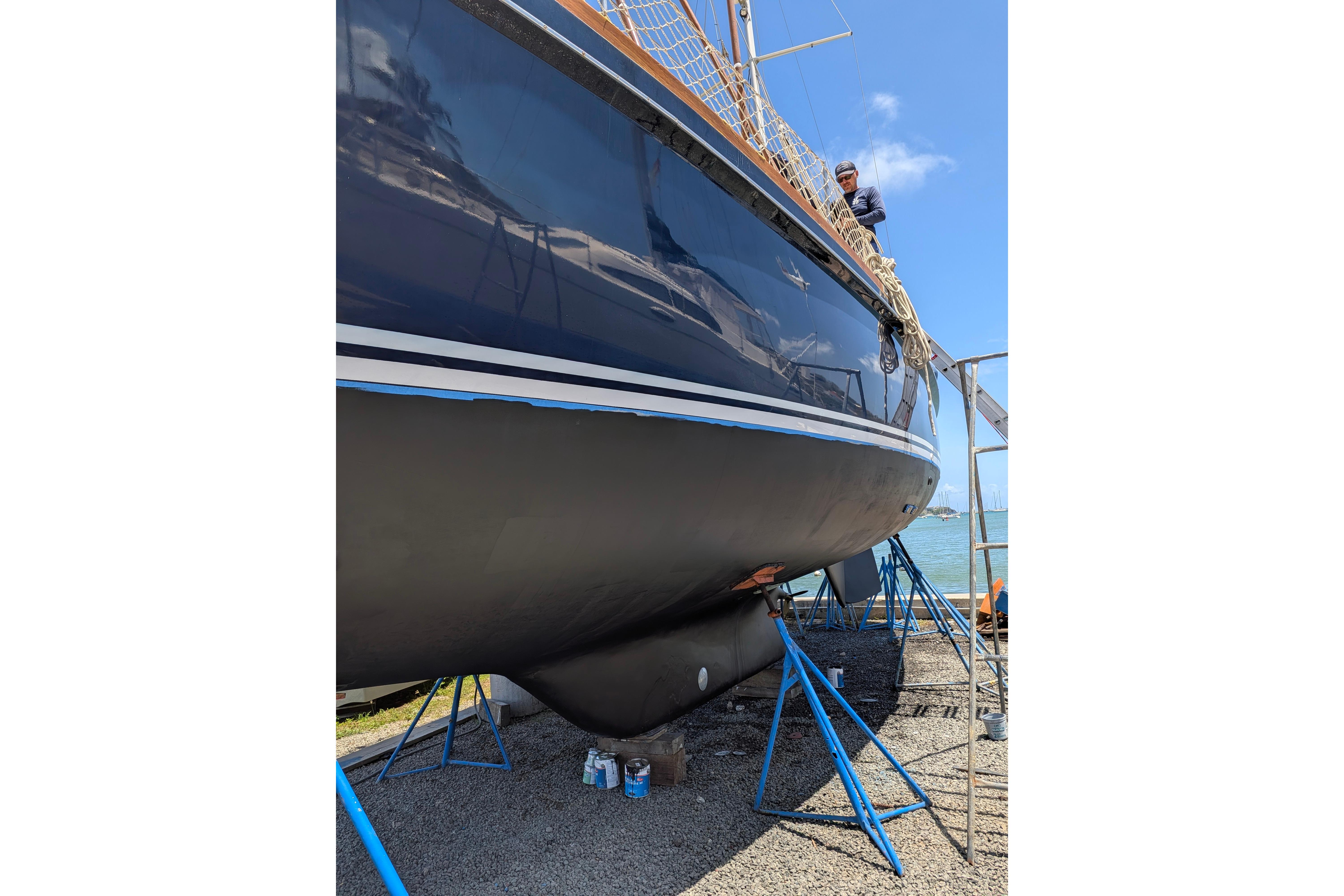 1974 Hinckley 49 sailboat on stands, undergoing maintenance by the water.