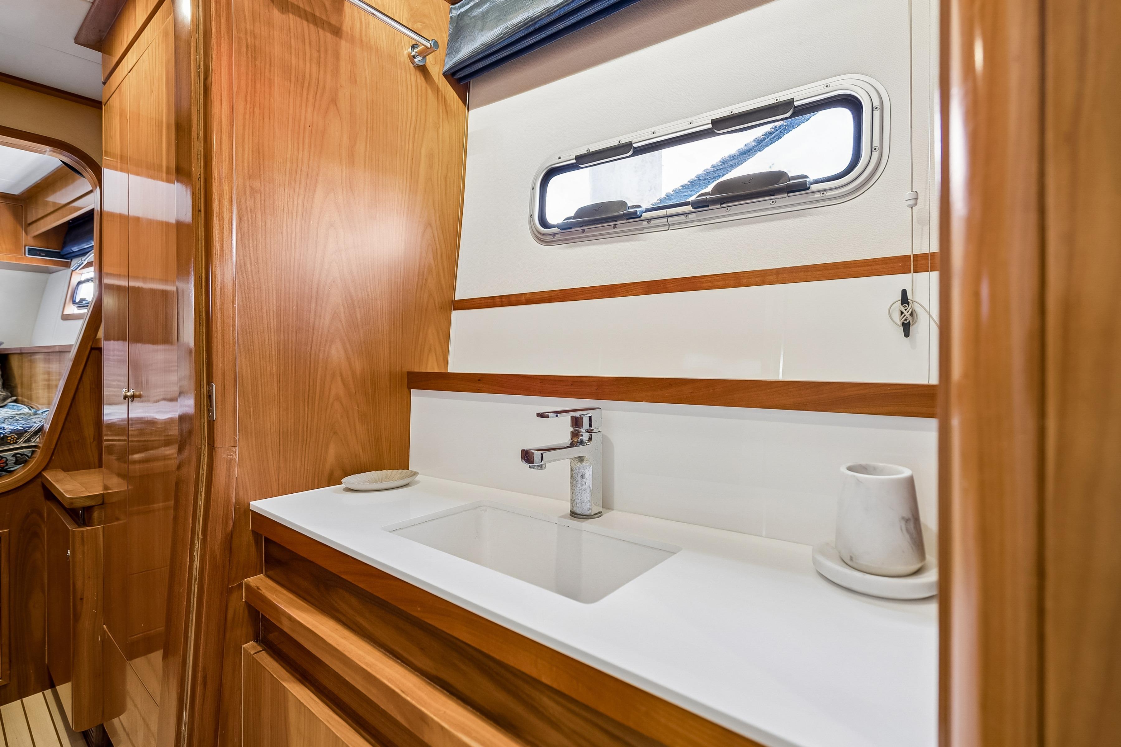 Luxurious Catana 65 yacht bathroom interior with wooden cabinetry and modern sink, 2009 model.
