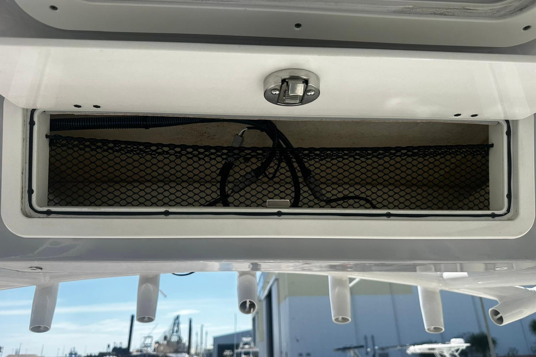 Storage compartment on a 2002 Sea Fox 228 Commander boat with netting and latch.