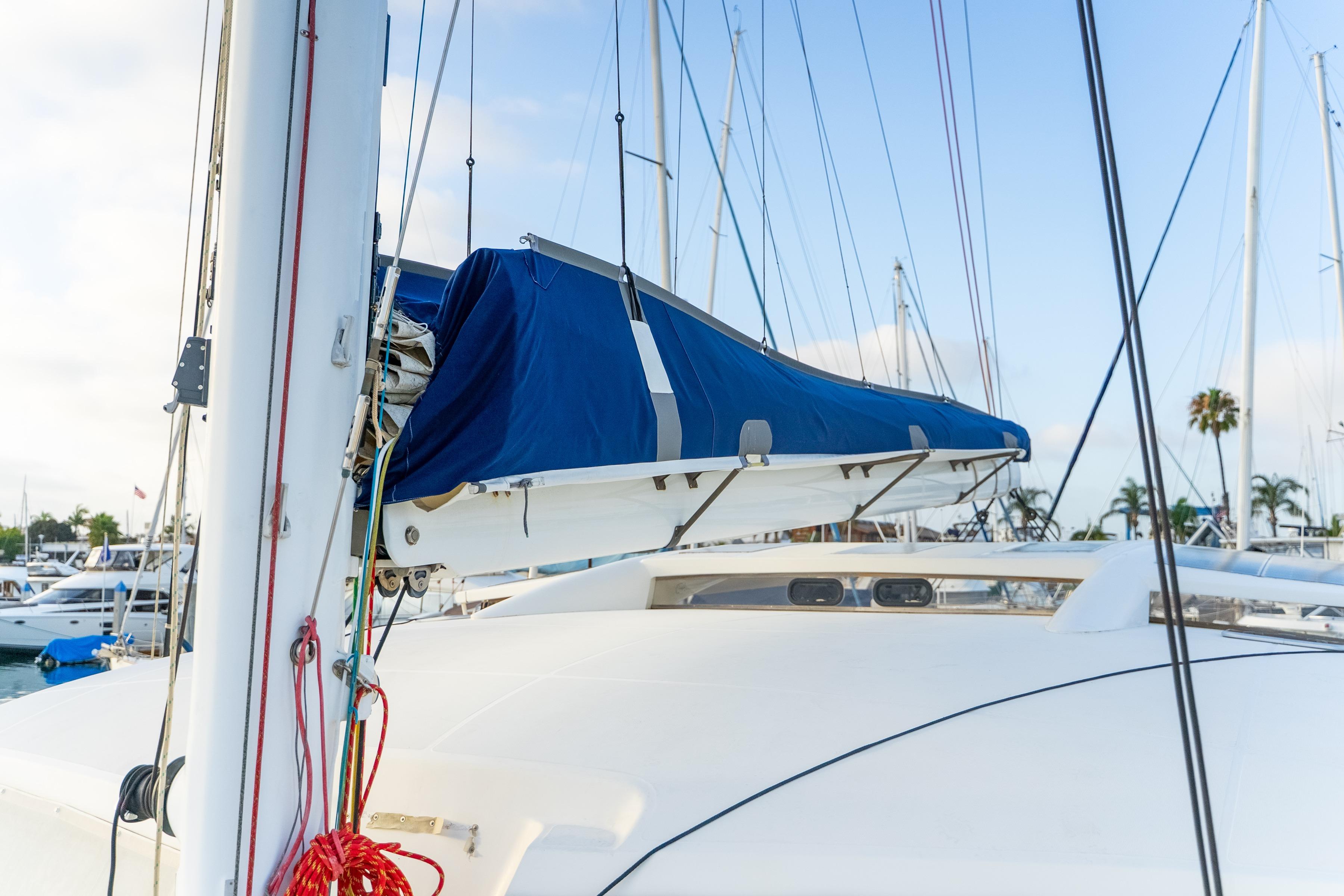 2009 Catana 65 sailboat with blue sail cover docked at marina.