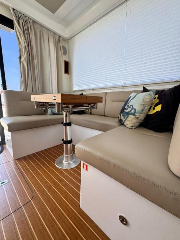 Luxurious interior of 2022 Rodman 1290 Evolution yacht with elegant seating and wooden flooring.