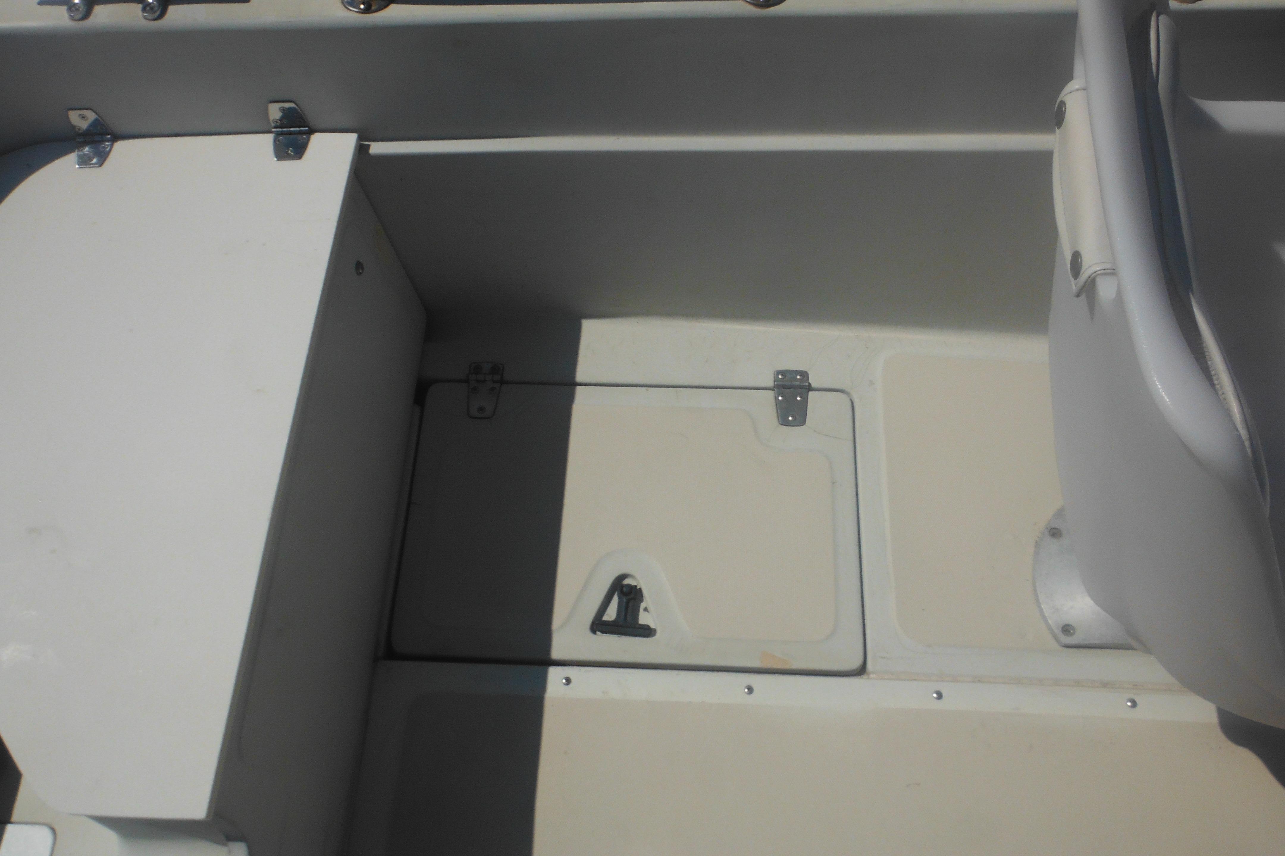 Interior view of a 1991 Boston Whaler 16 SL boat, featuring storage compartments.