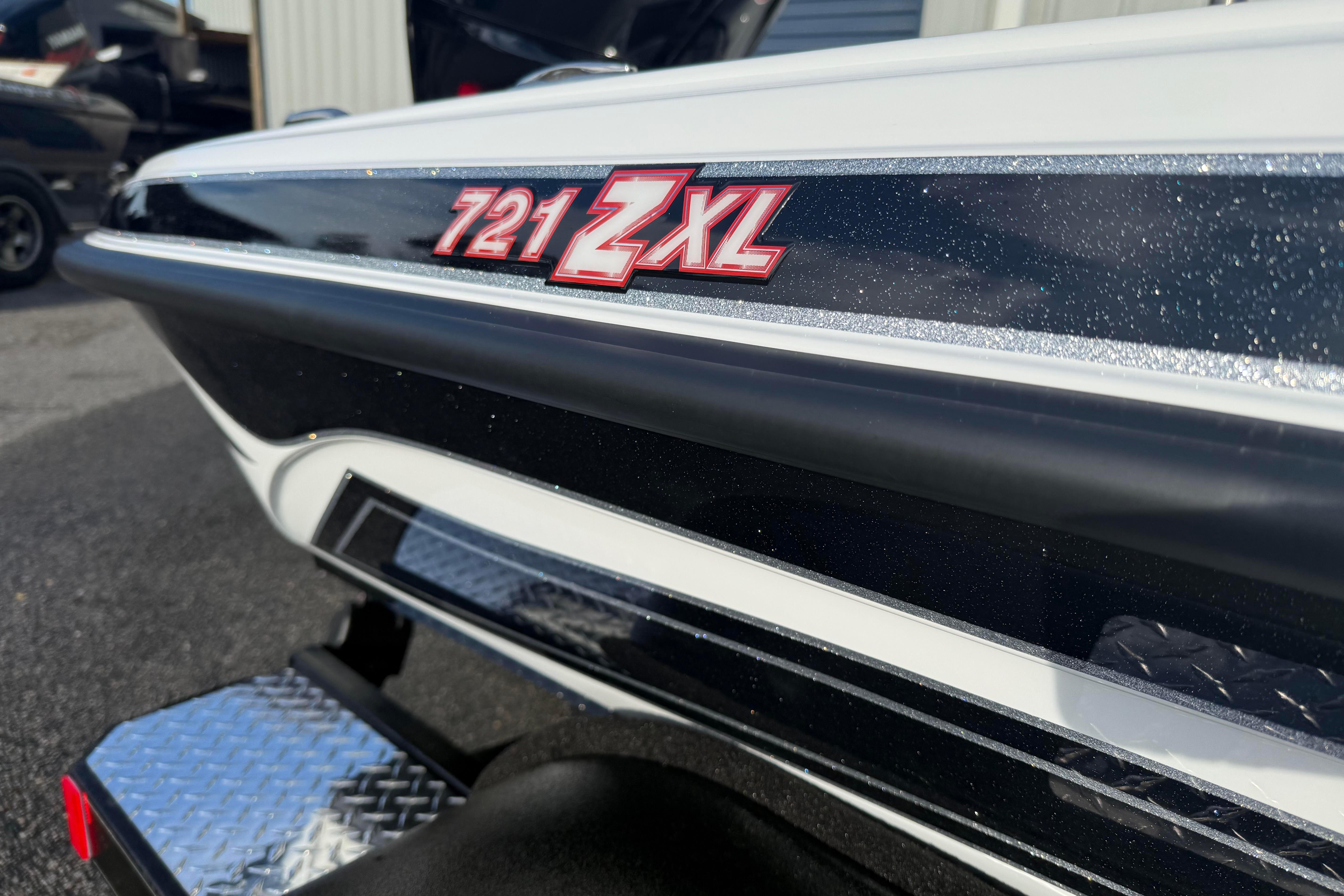 Close-up of 2027 Phoenix 721 ZXL boat model emblem on sleek black and white exterior.