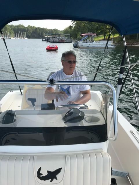 Man steering 2006 Mako 171 Center Console on a lake.