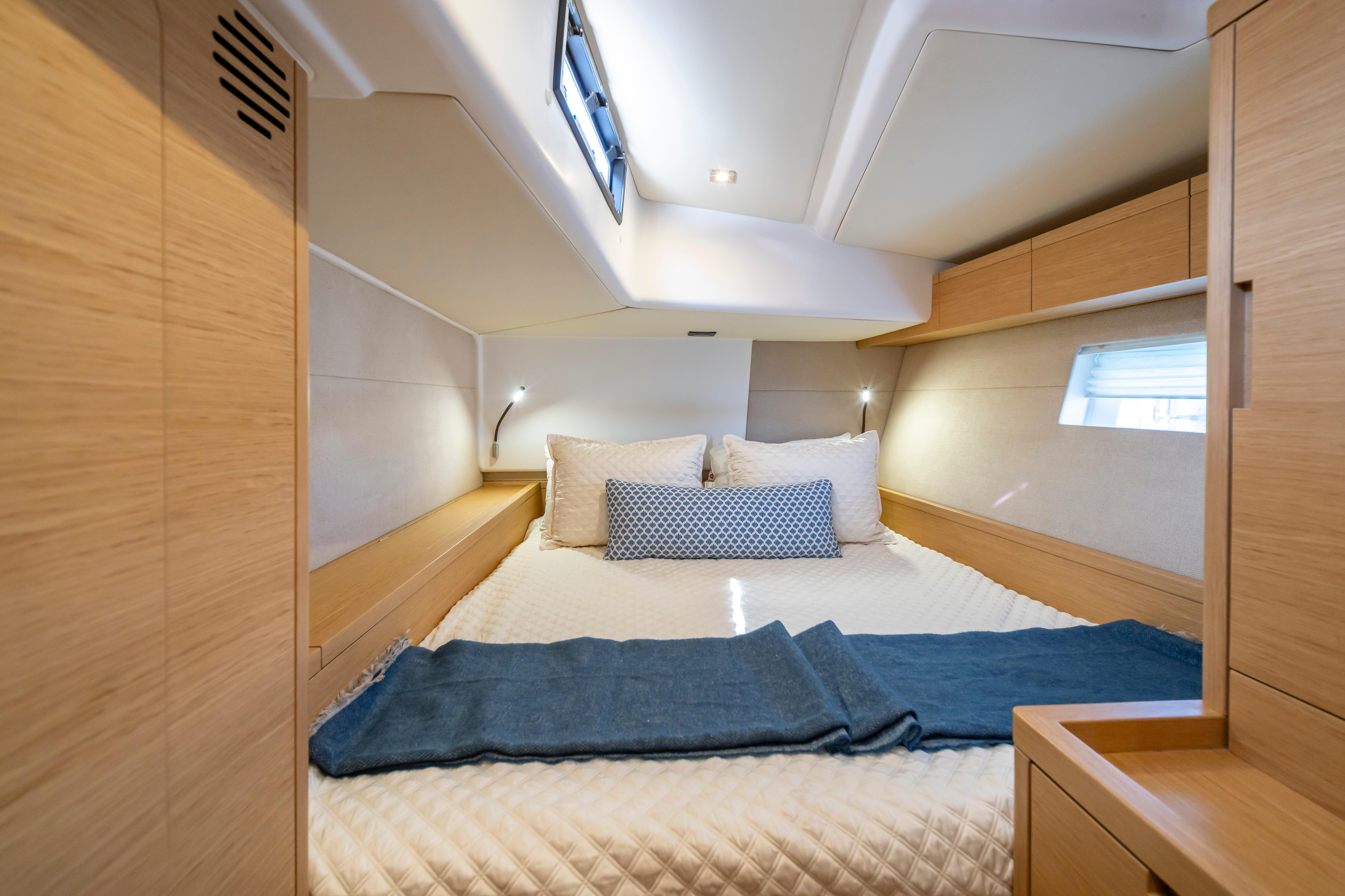 Luxurious cabin interior of 2016 Grand Soleil 58 yacht with cozy bedding and modern design.
