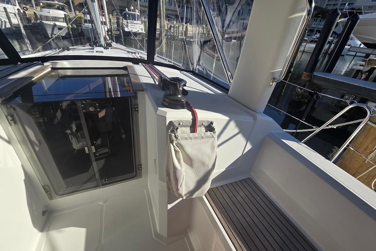 Cockpit view of 2023 Beneteau Oceanis 38.1 sailboat, featuring sleek design and marina backdrop.