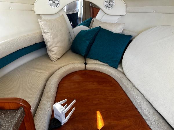 2004 Rinker Fiesta Vee 250 cabin interior with cozy seating and cushions.