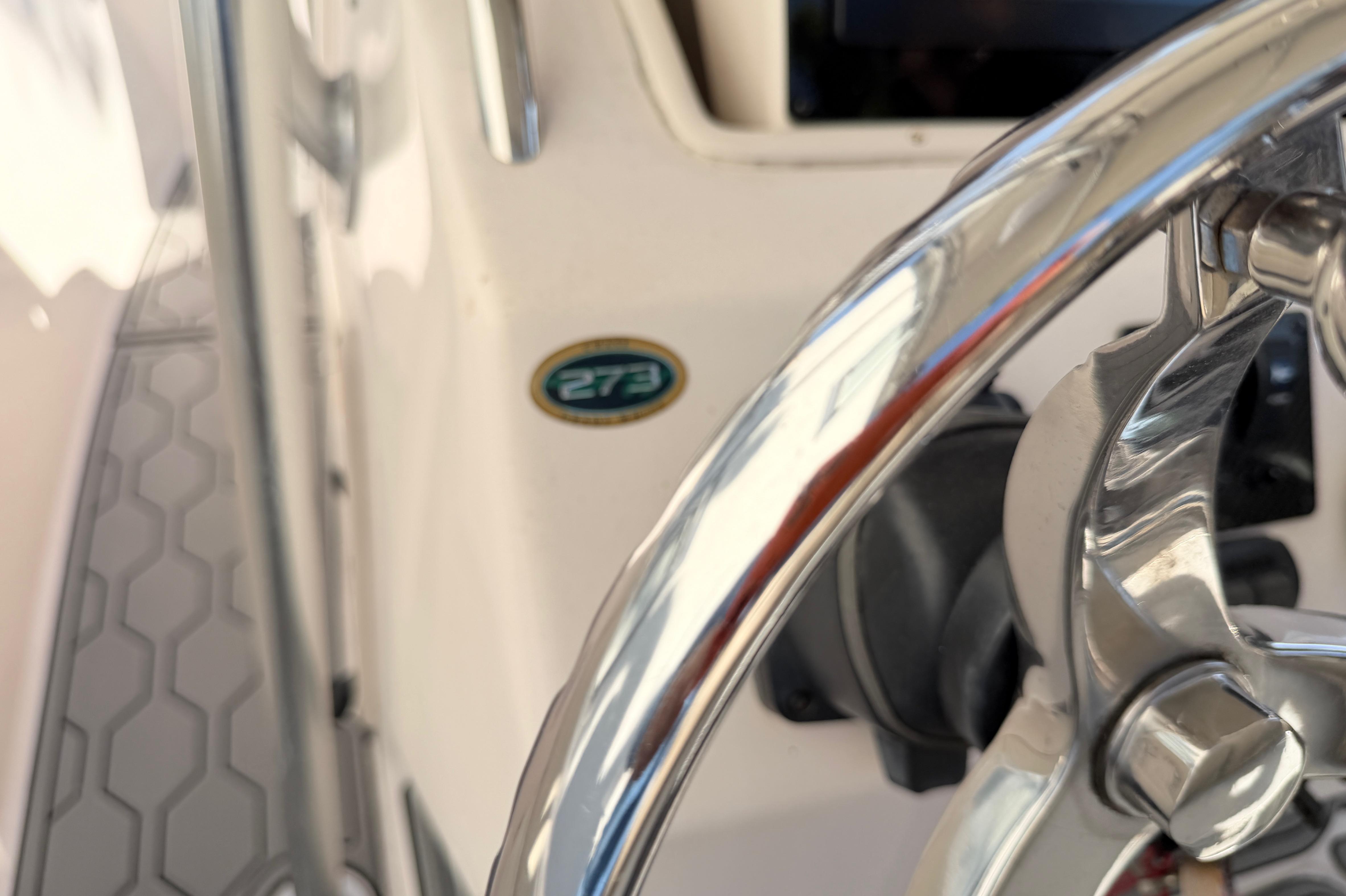 Close-up of a 2004 Grady White 273 boat steering wheel and model badge.