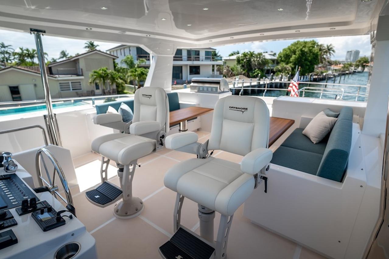 Luxurious interior of 2027 Offshore Yachts 70 CE, featuring plush seating and modern controls.