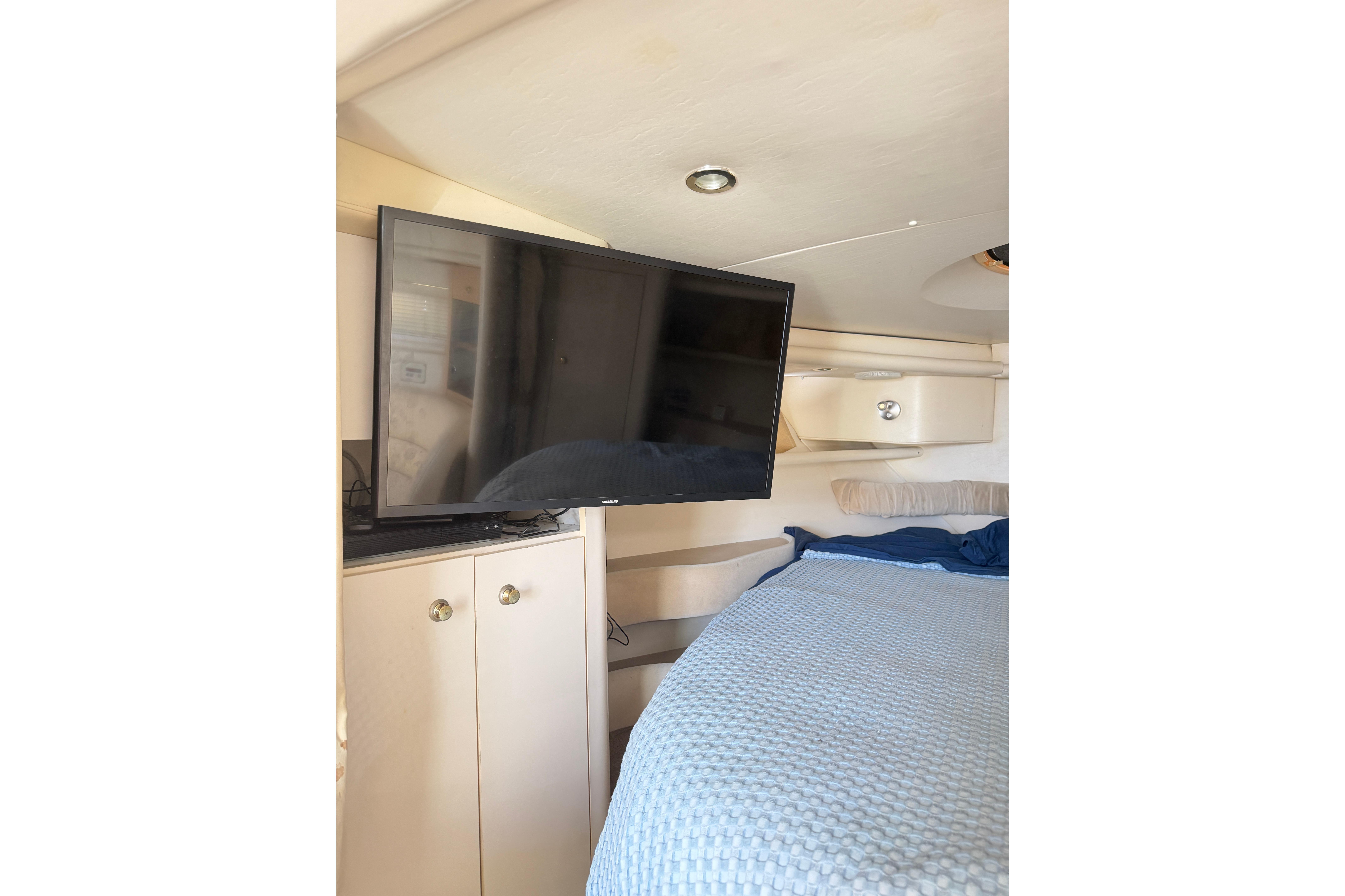 Interior of 2000 Maxum 3700 SCR yacht with TV and cozy bed.