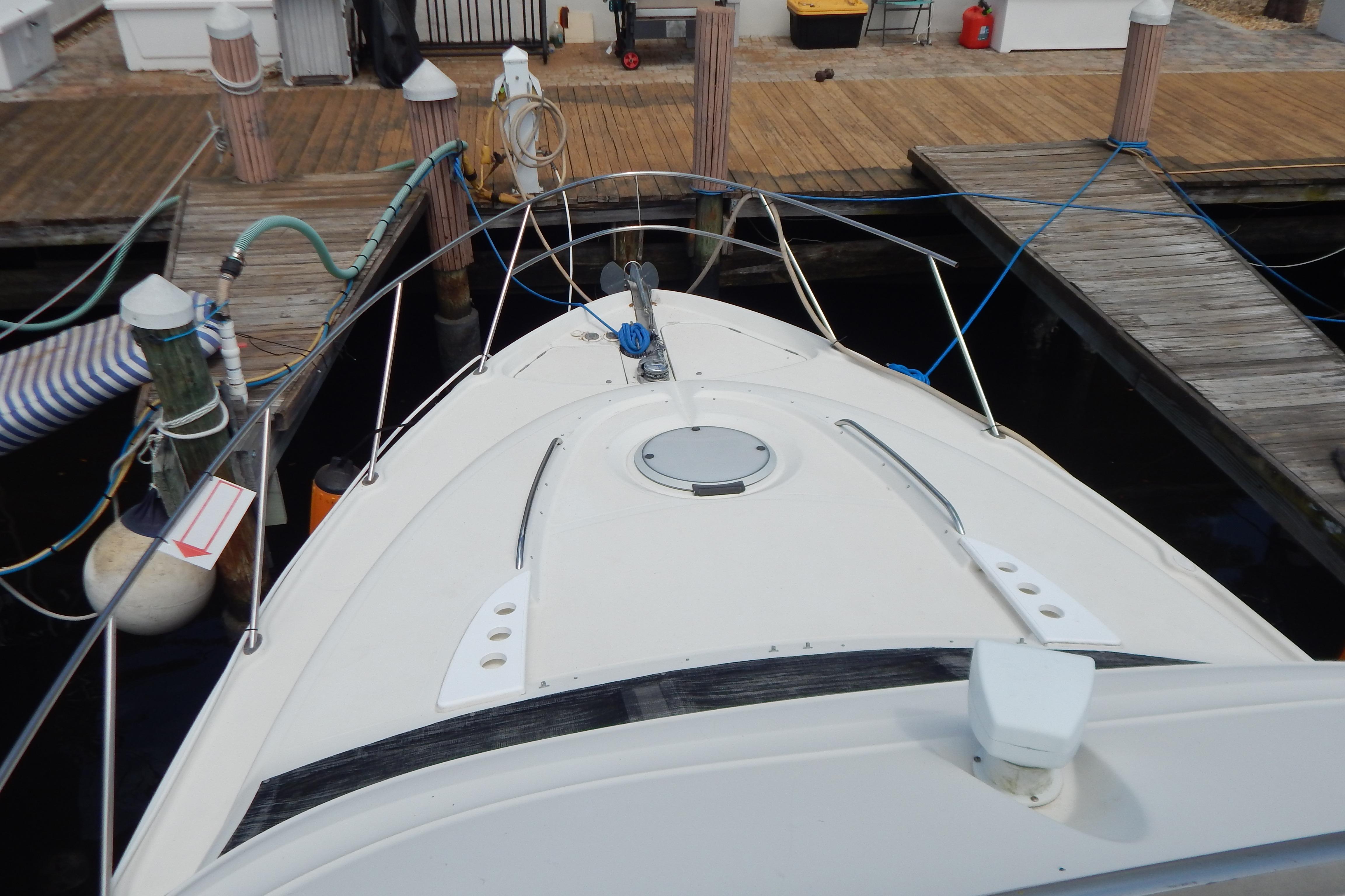 1998 Magnum 4100 SCR boat docked at marina with wooden piers and nautical equipment.