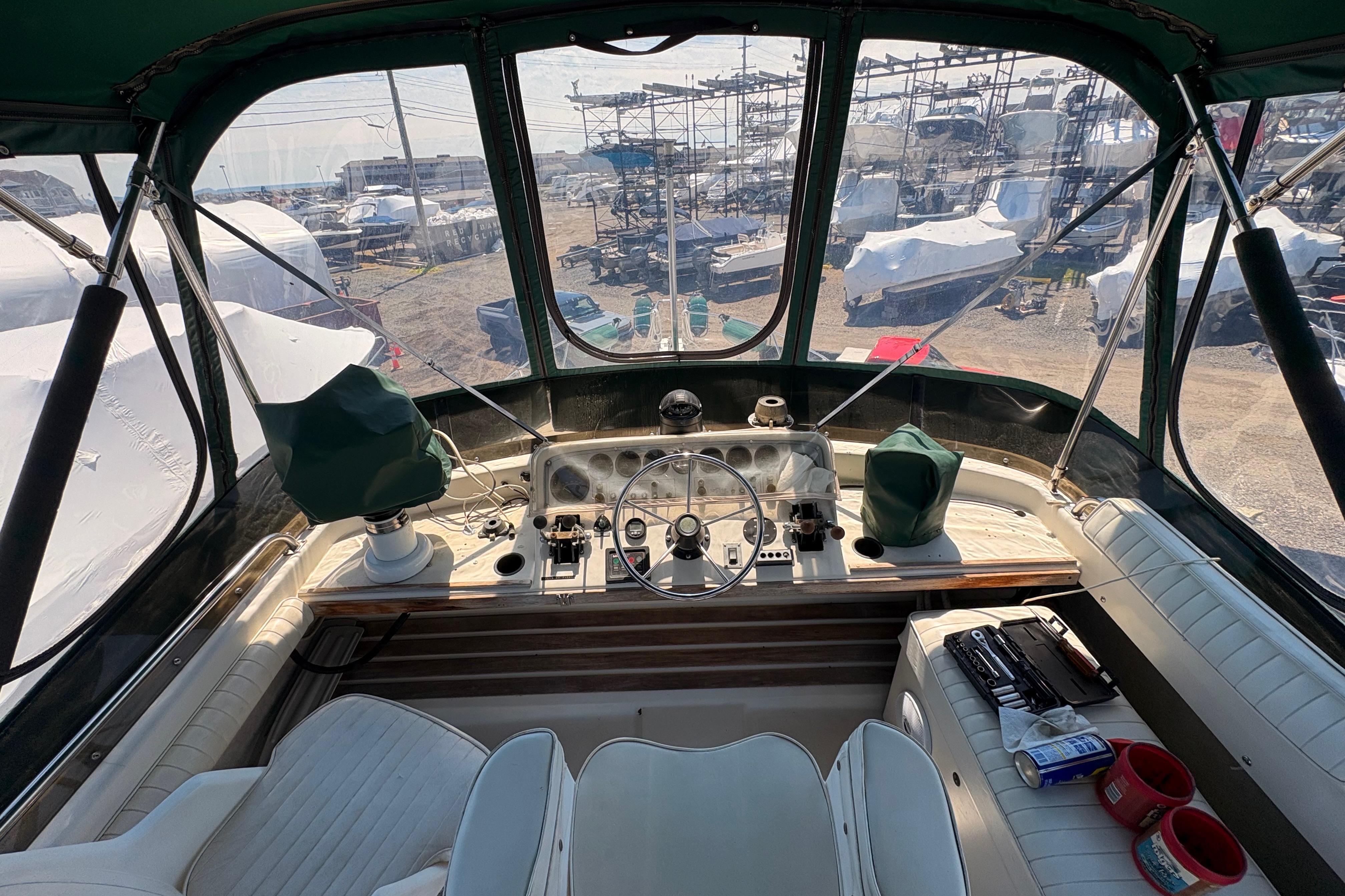 1984 Silverton 34 Convertible boat cockpit with steering wheel and controls, docked in a marina.