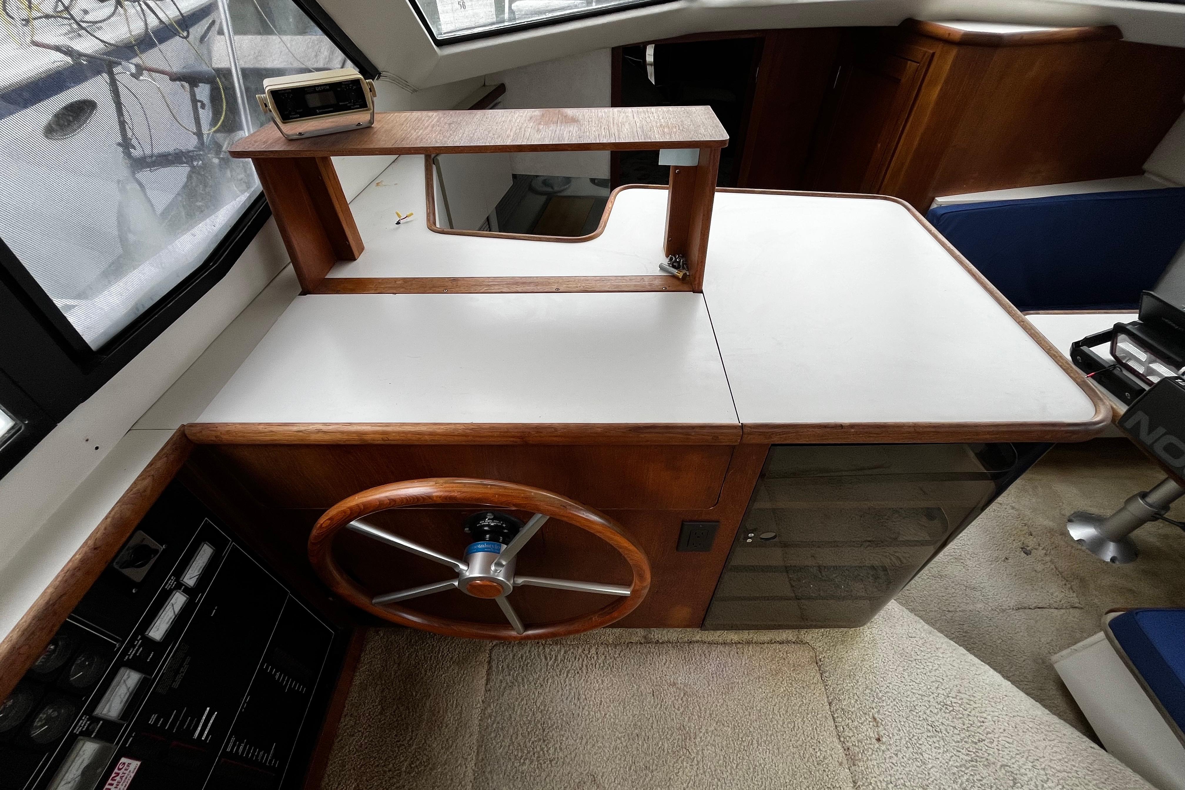 1991 Carver 33 Aft Cabin Motor Yacht helm with wooden steering wheel and navigation equipment.