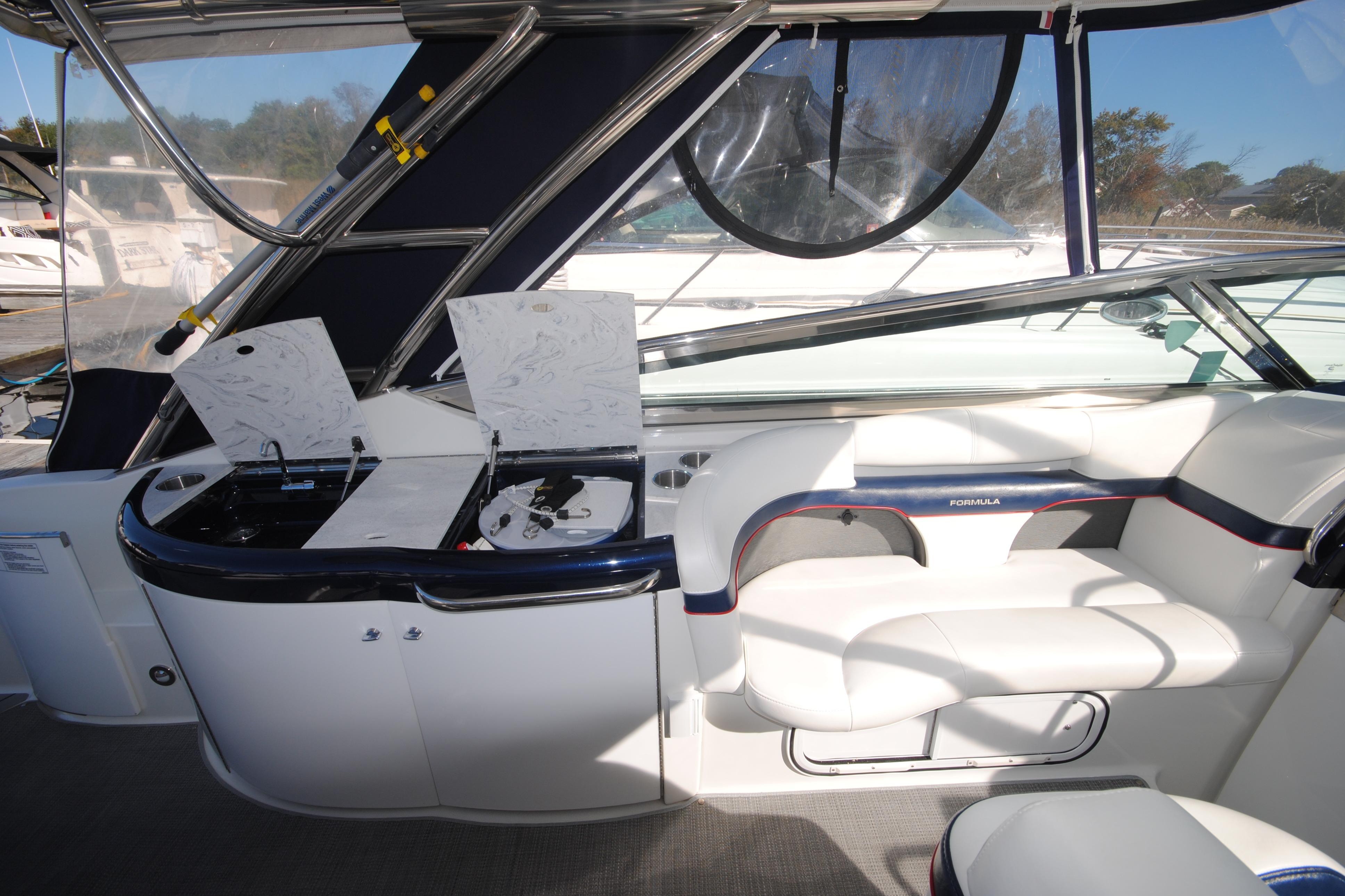 2017 Formula 370 Super Sport boat interior with white seating and open storage compartments.