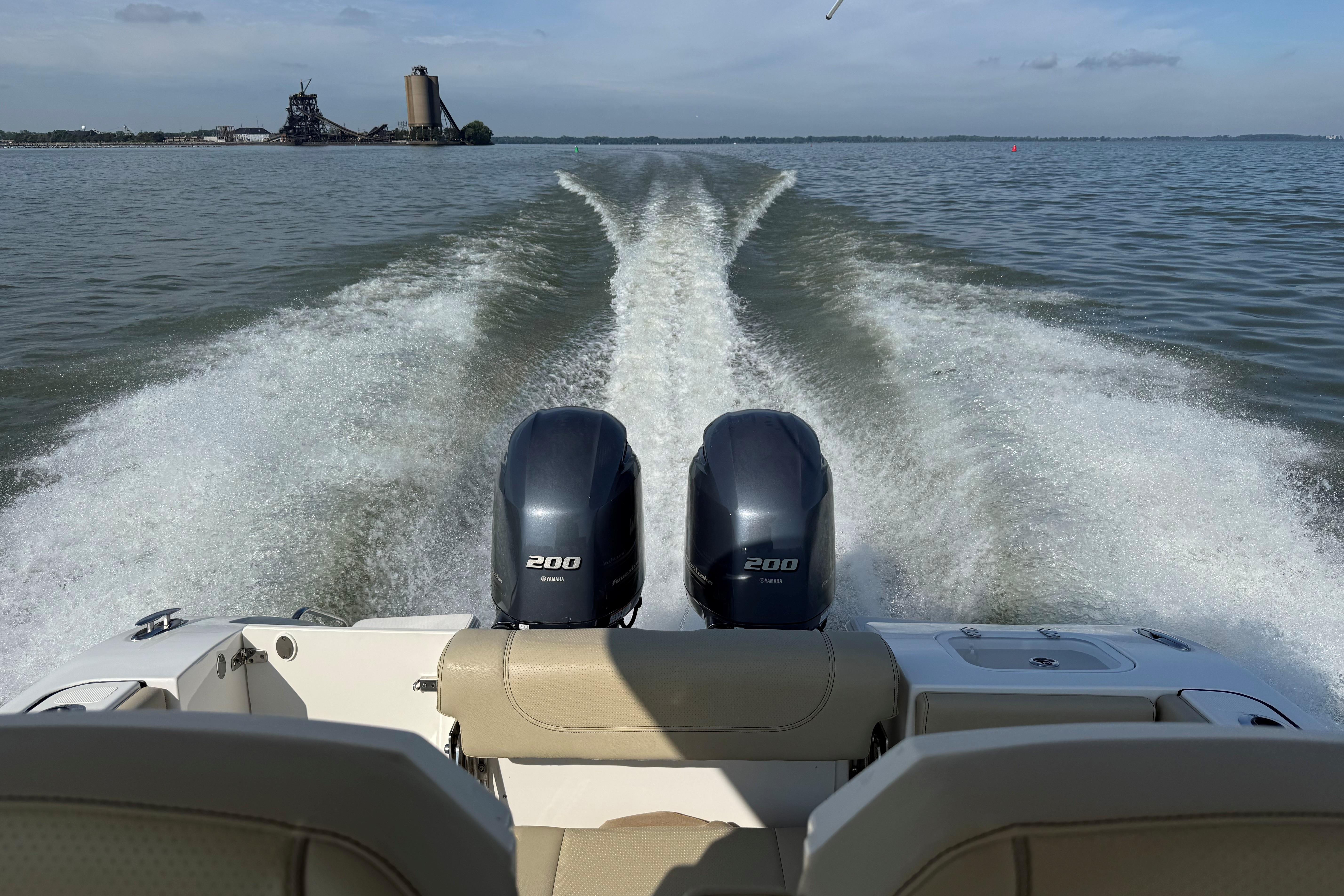2021 Pursuit S 268 Sport boat with twin engines cruising on open water.