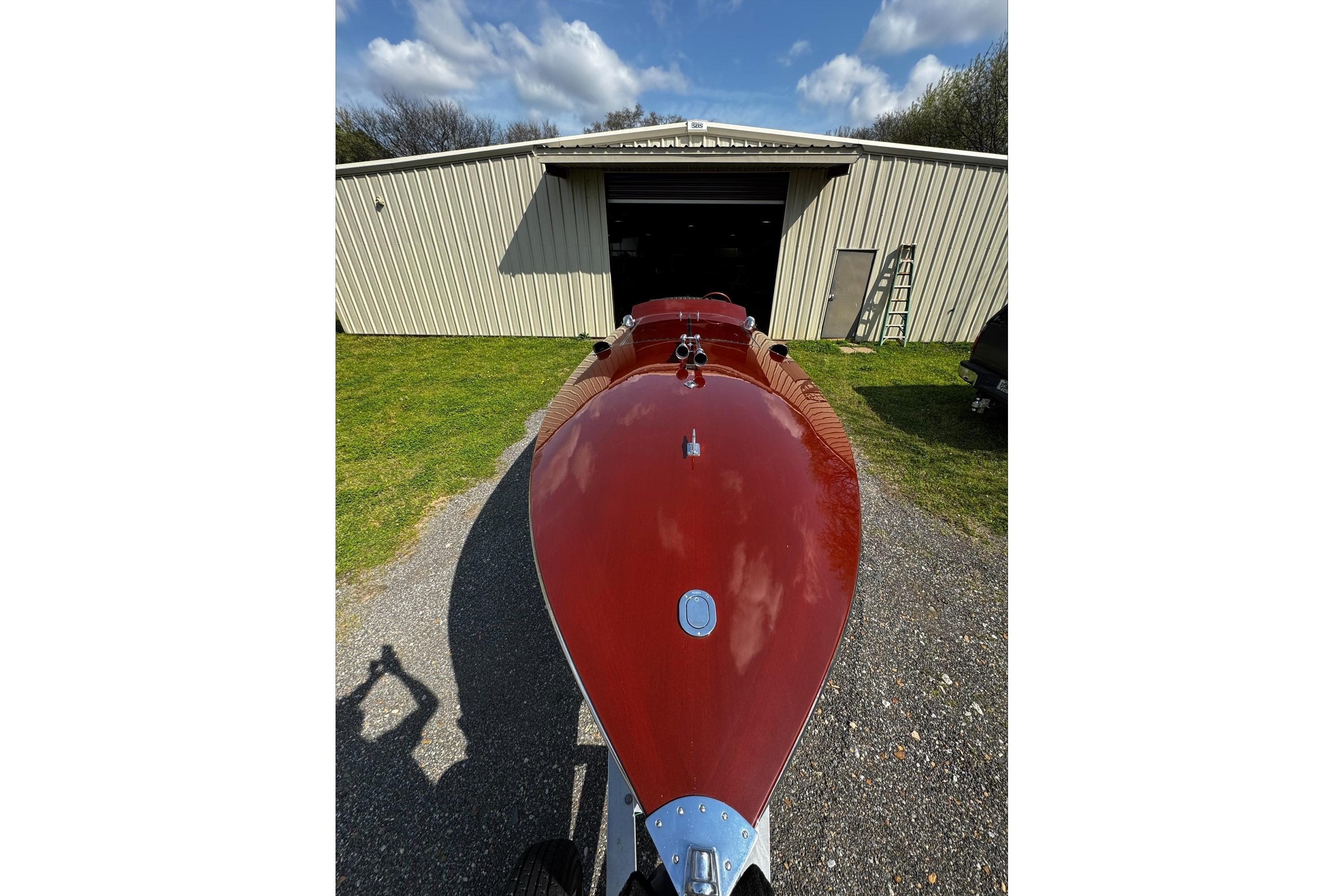 2014 Hacker-Craft 26' Runabout in front of a garage under a blue sky.