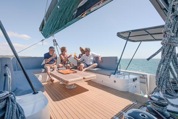 Four people relaxing on a 2025 Privilege Signature 650 yacht deck.