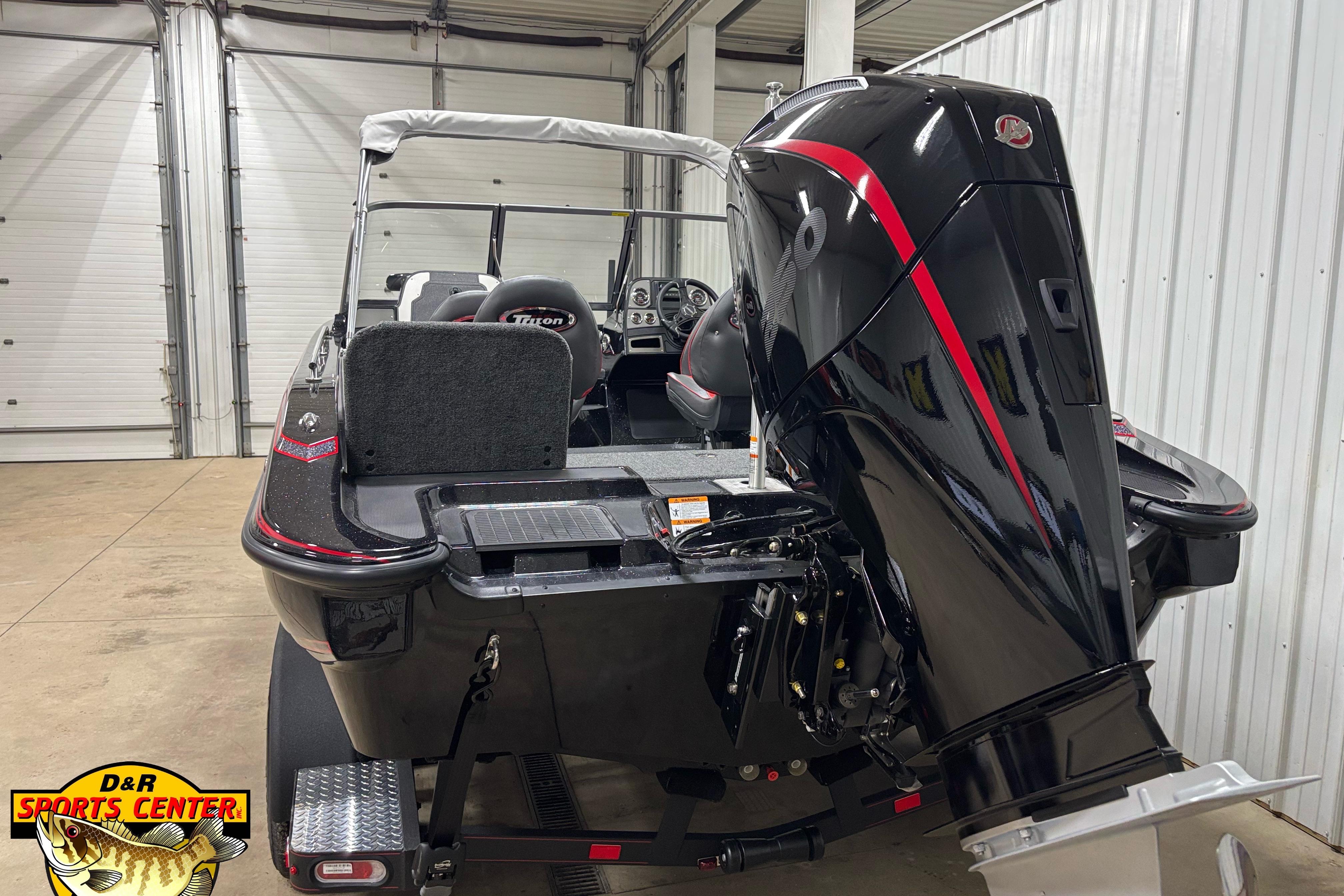 2026 Triton 206 Allure boat in showroom, featuring powerful outboard motor.