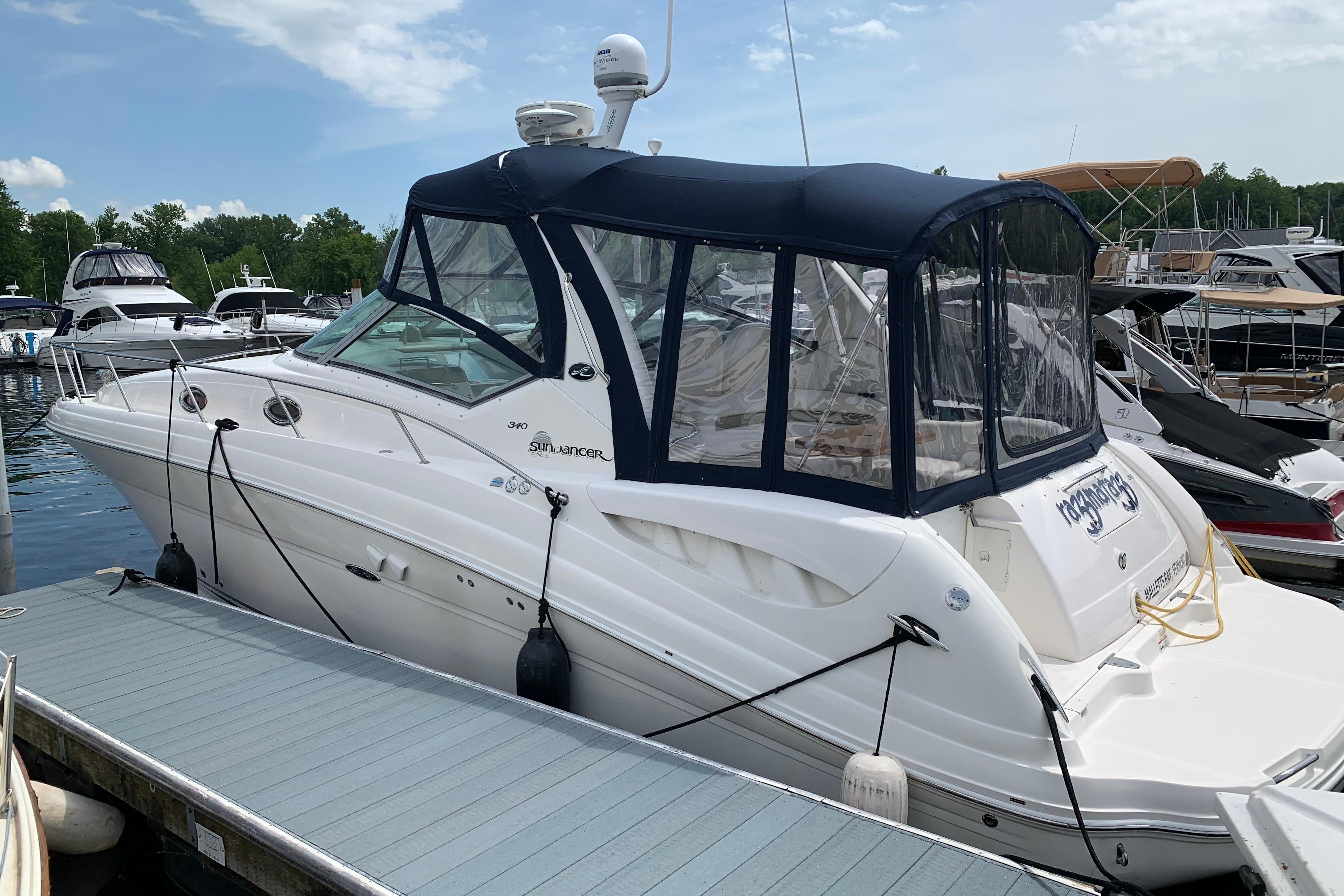 2007 Sea Ray 340 Sundancer docked at marina, featuring sleek design and blue canopy.