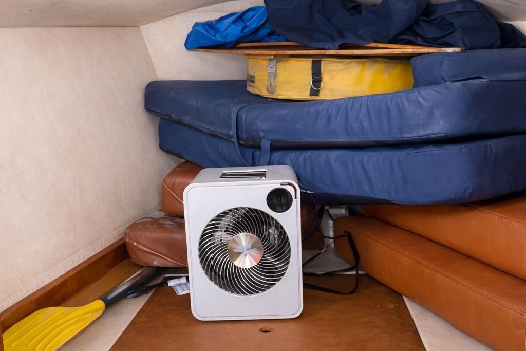Interior of 1979 Lancer Sloop with cushions, fan, and paddles stored neatly.