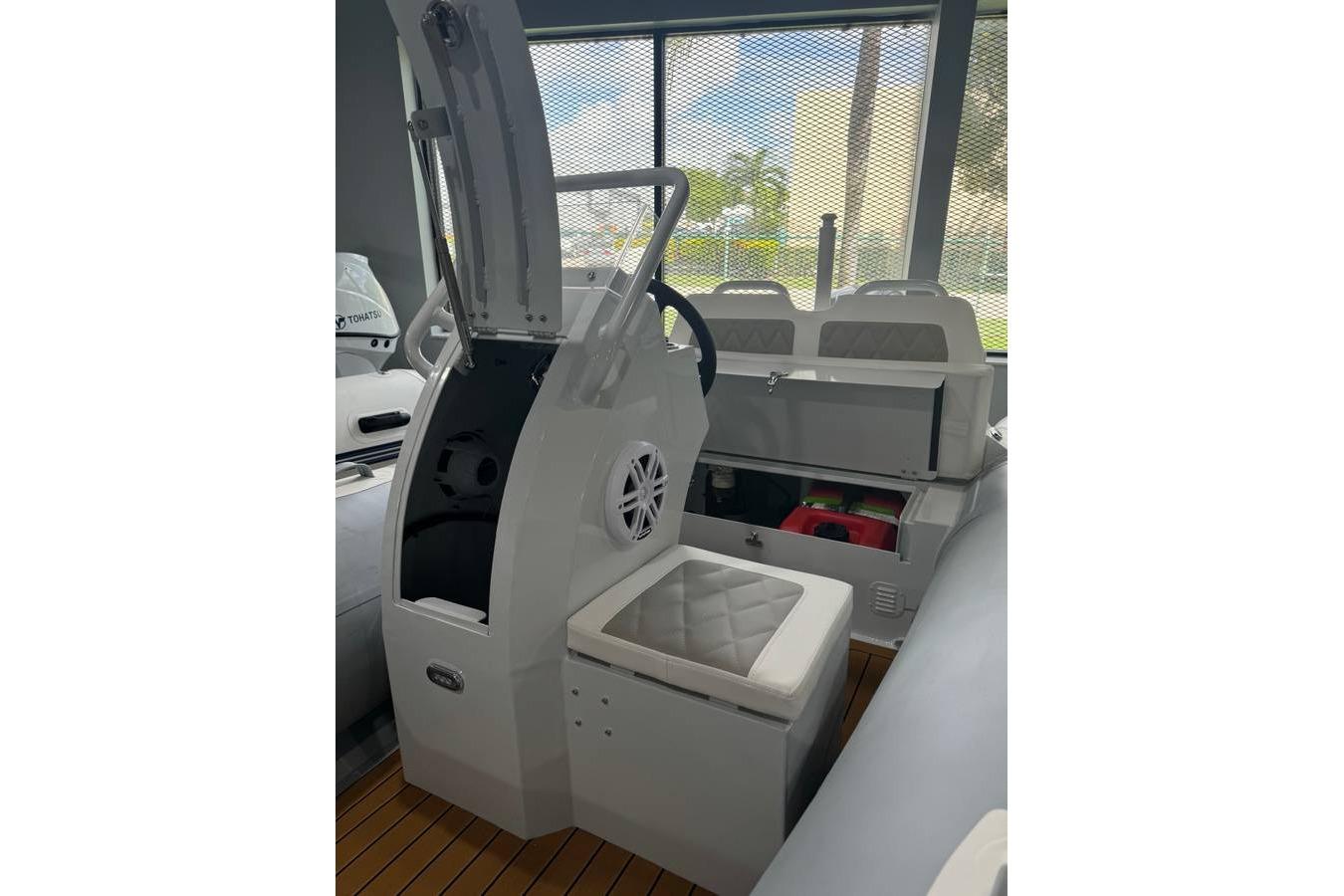 2026 East Marine 360 boat interior with steering console and cushioned seating.