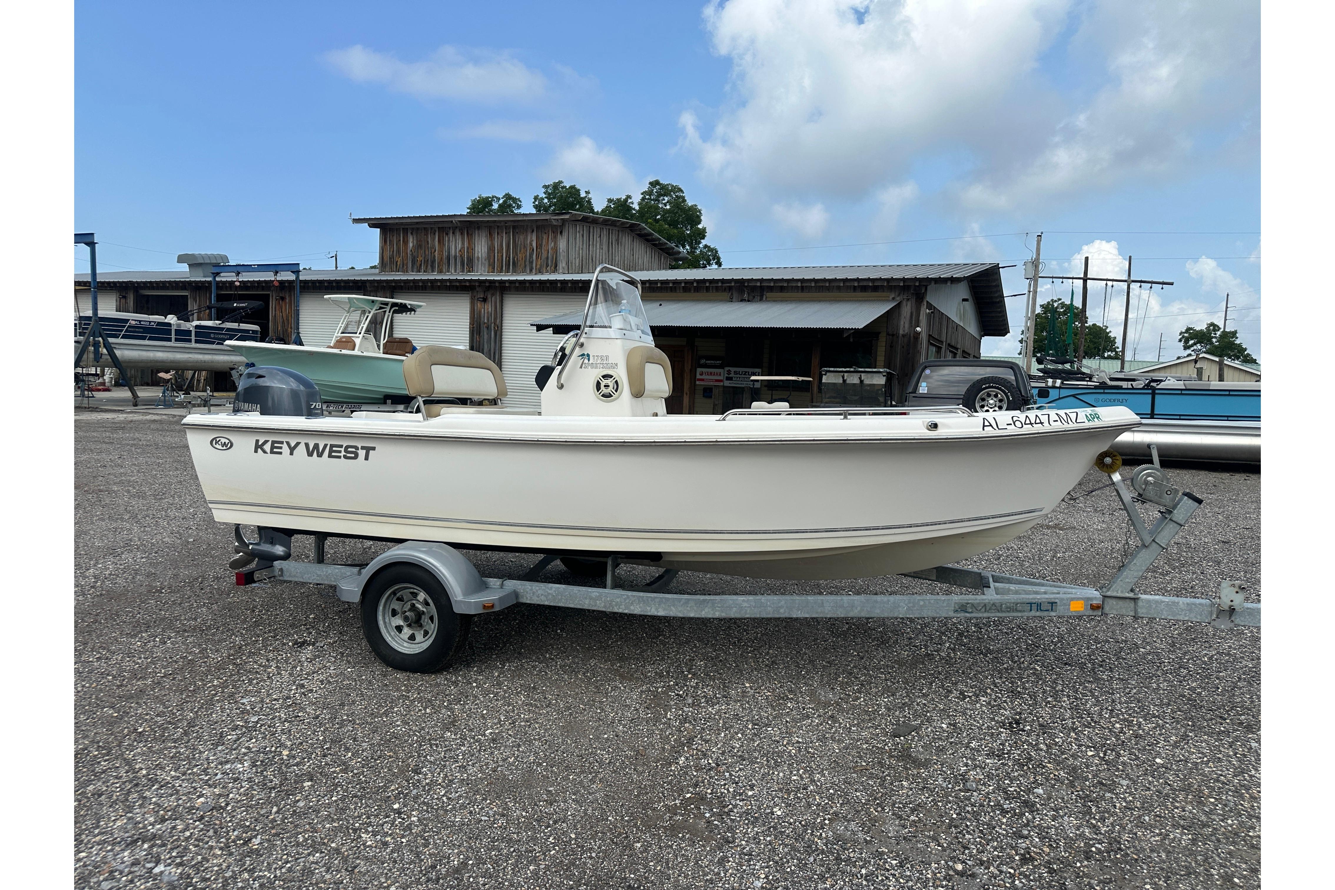 2018 Key West 1720 Center Console boat on trailer, parked outdoors under a cloudy sky.