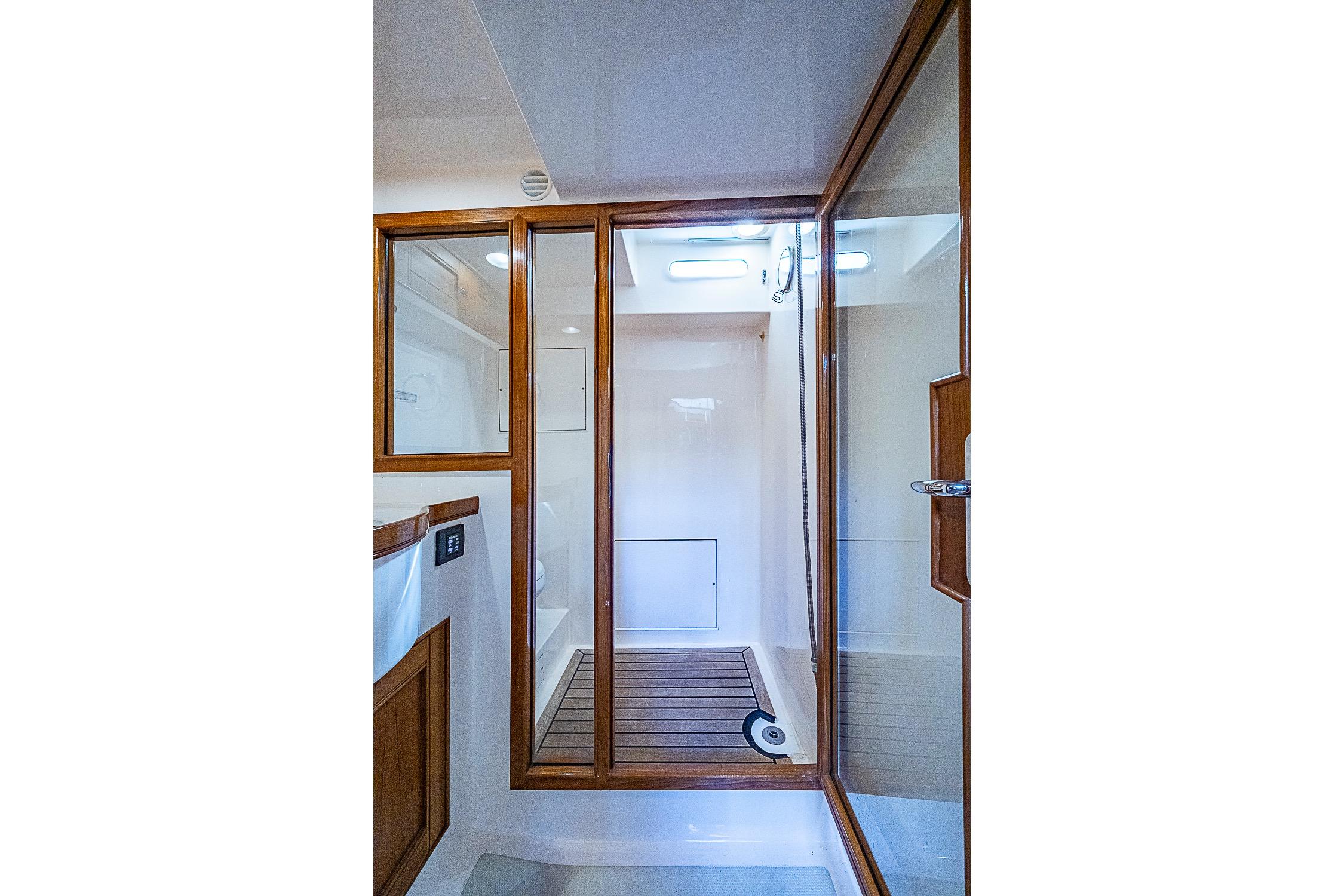 Luxurious shower area in 2014 Marlow 80 Explorer yacht with wooden accents.