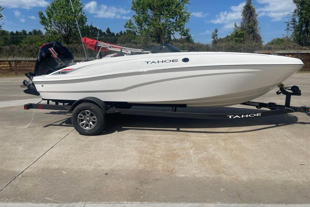 2026 Tahoe T18 boat on trailer, parked outdoors under a clear blue sky.
