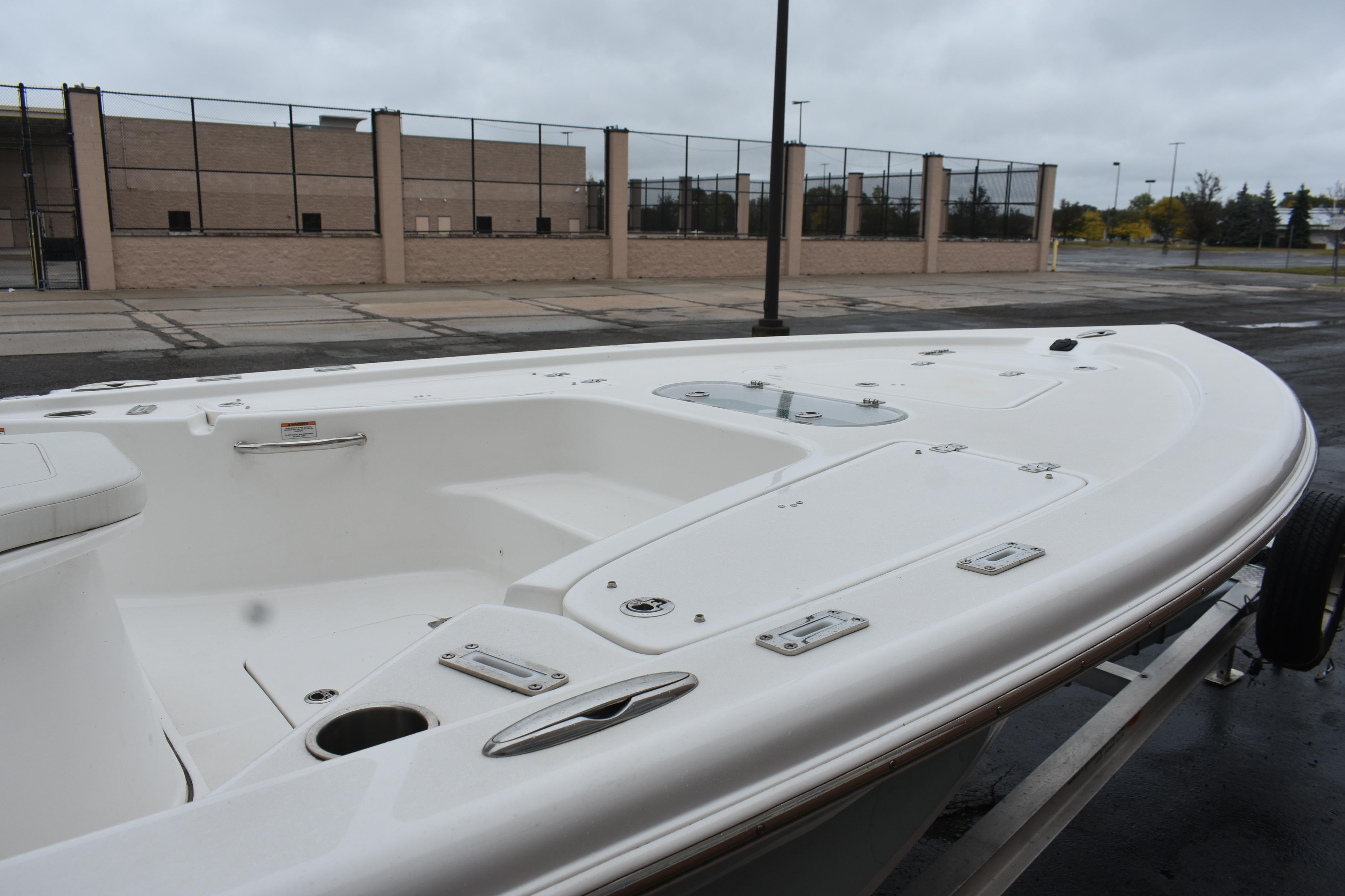 2025 Sea Pro 250 Bay boat, white deck, parked outdoors on a cloudy day.