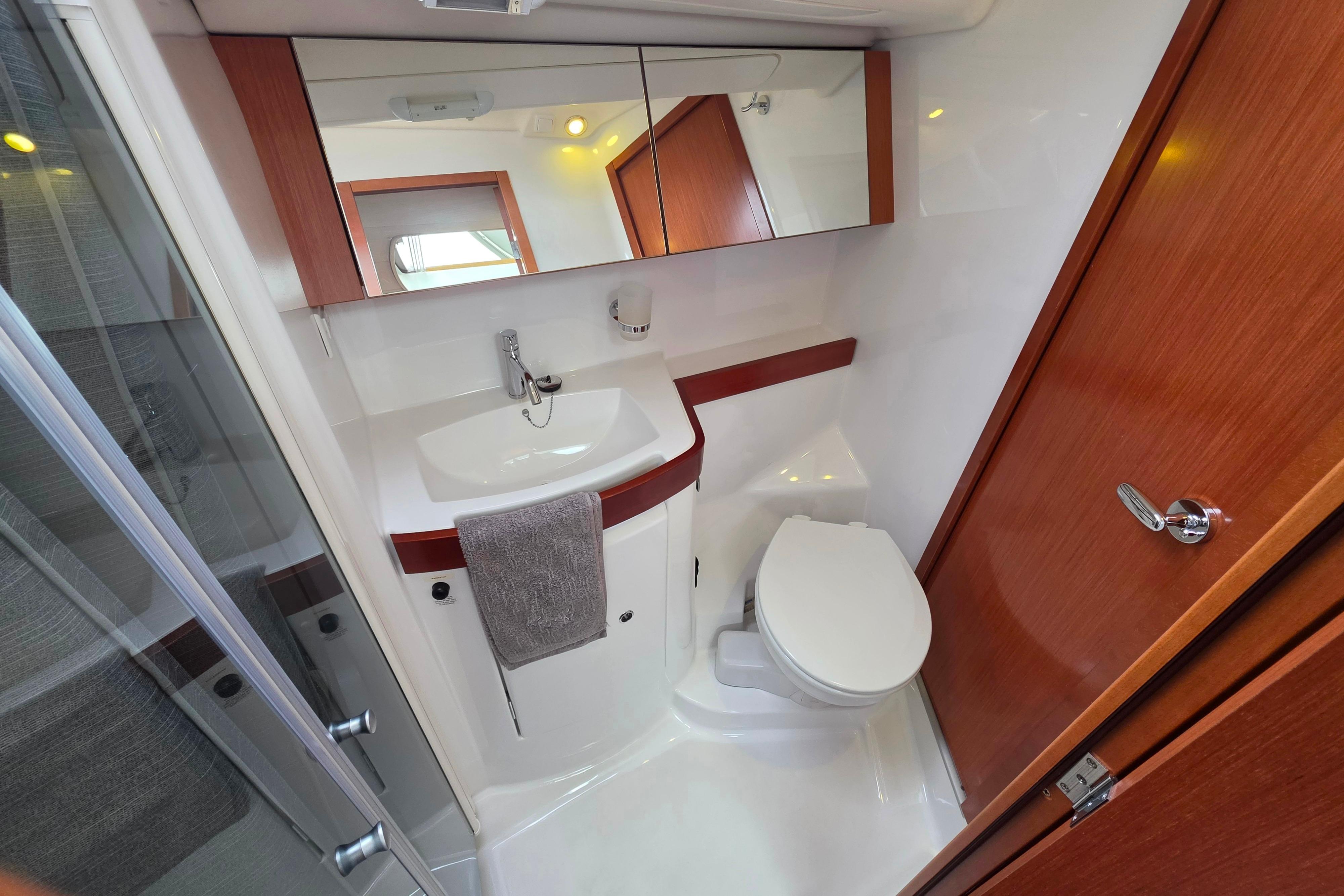 Bathroom interior of 2010 Beneteau Oceanis 40 yacht, featuring sink, toilet, and mirror.