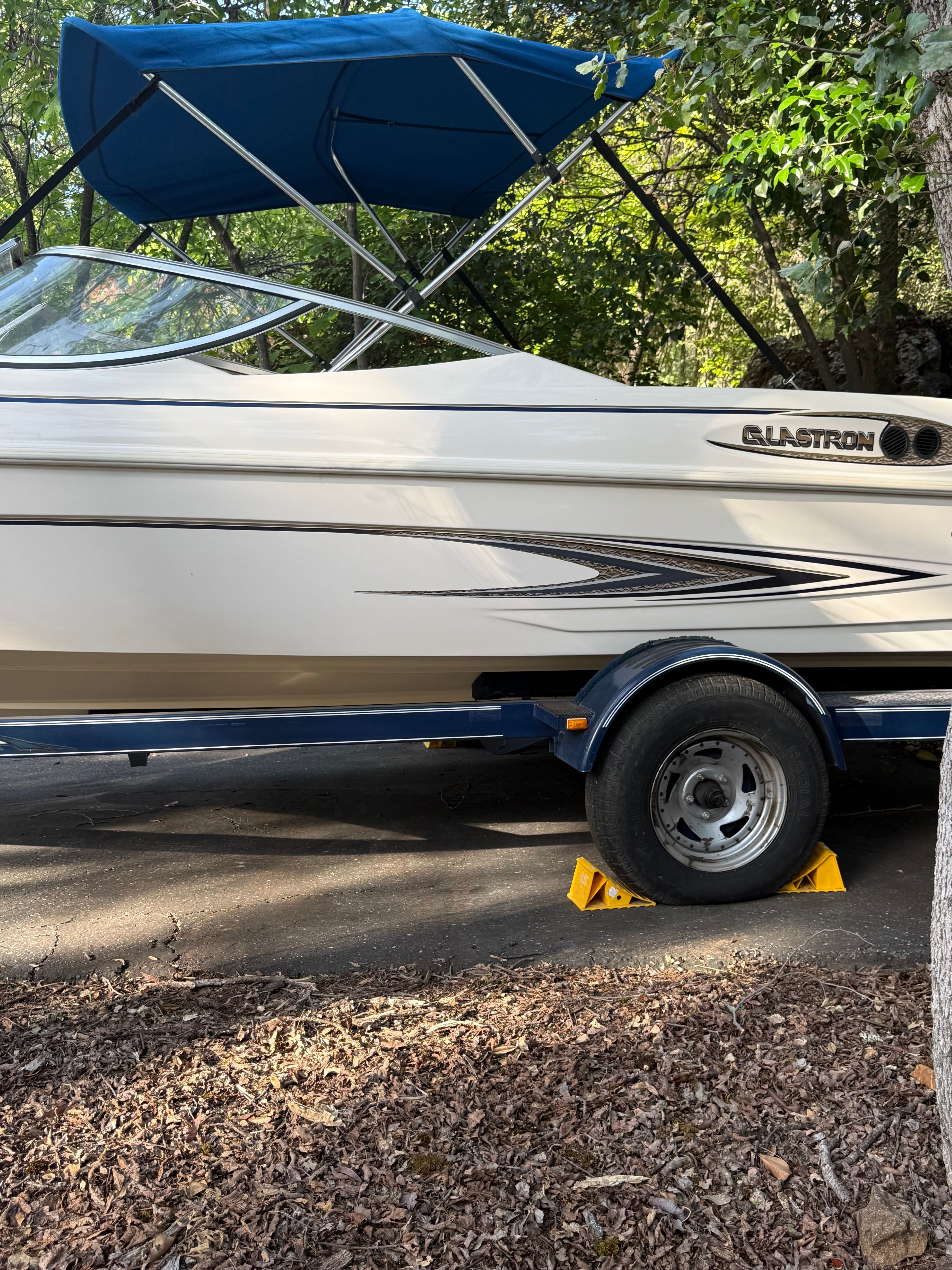 2003 Glastron SX 195 boat with blue canopy on trailer.