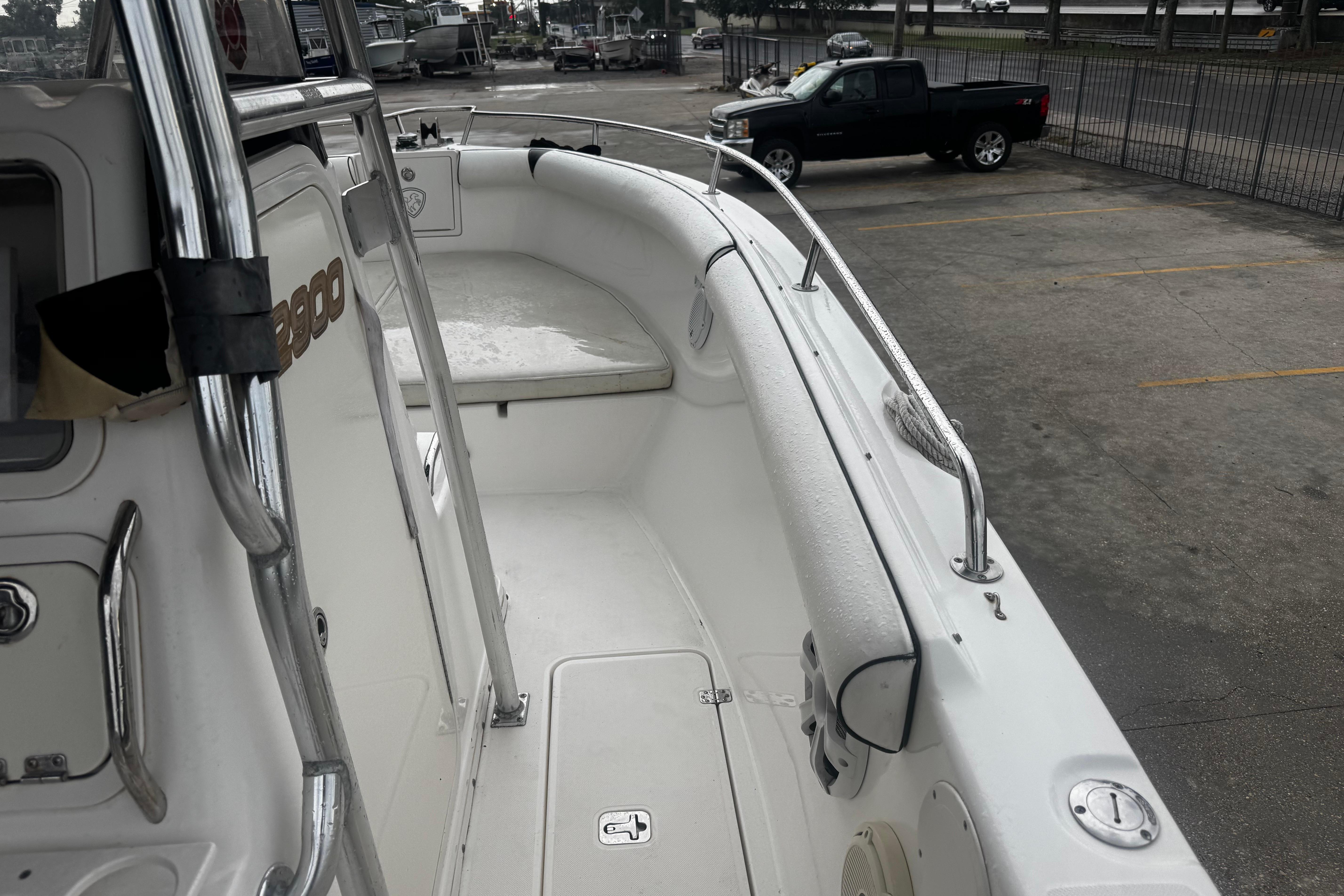 2004 Century 2900 Center Console boat interior with seating and railing, parked in a lot.