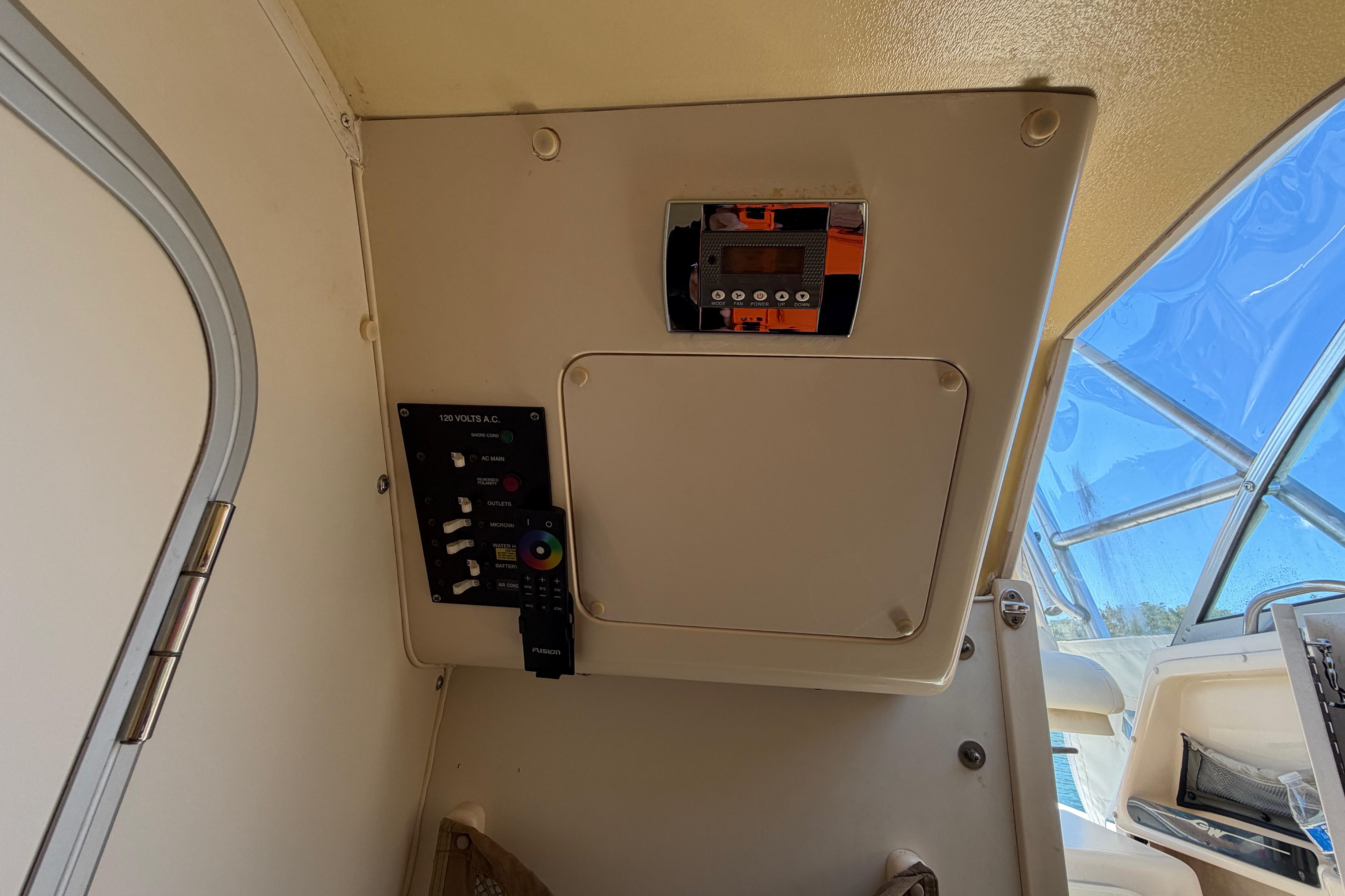 Control panel inside 2006 Grady-White Sailfish 282 boat, featuring electrical switches and a stereo system.