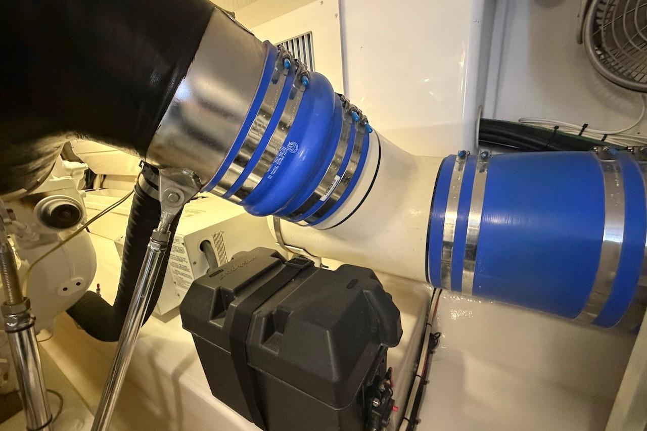 Engine room of 2012 Viking 50 Convertible yacht with blue hoses and components.