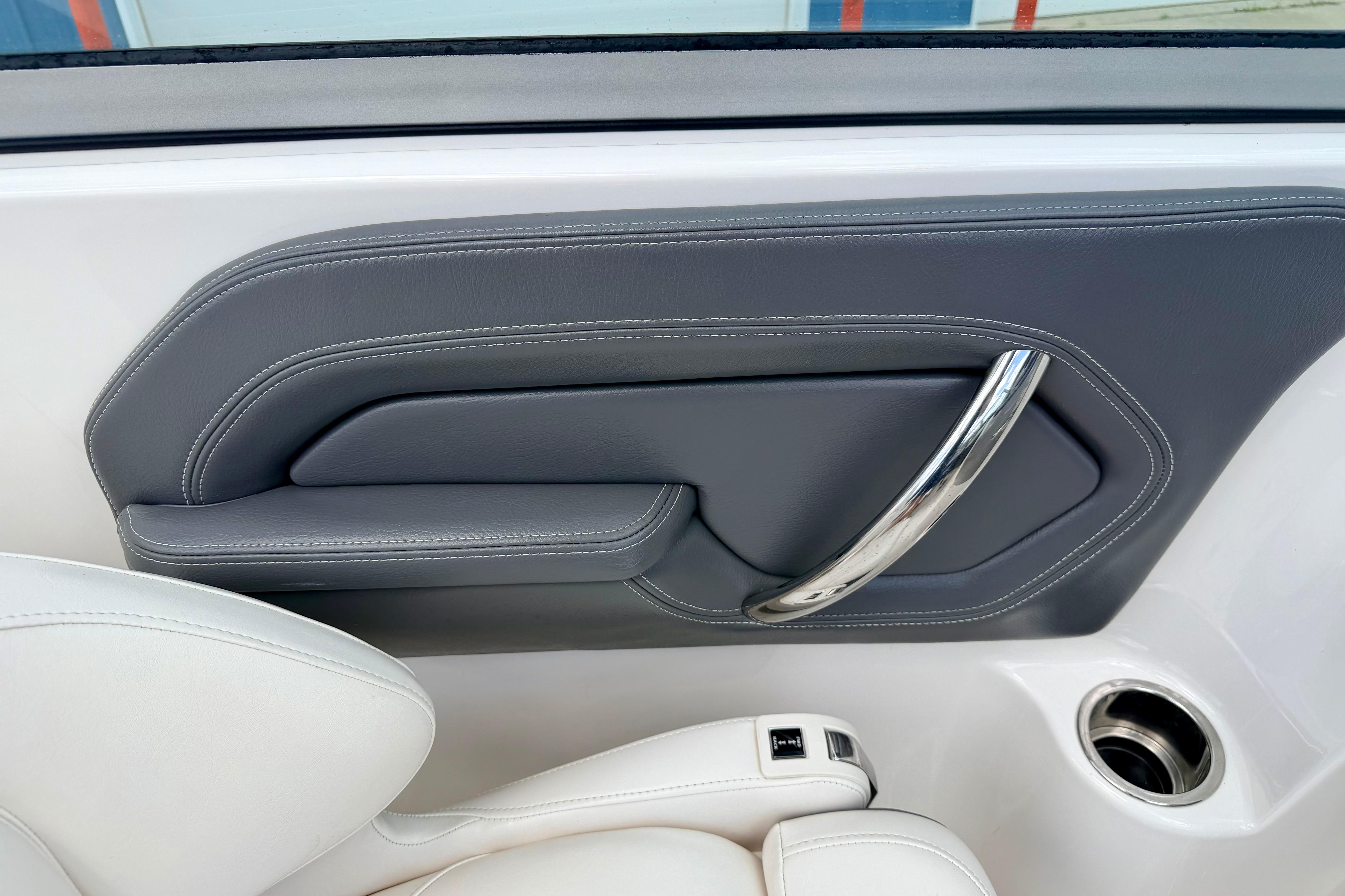2015 Chaparral Sunesta 264 interior detail with sleek gray panel and chrome handle.