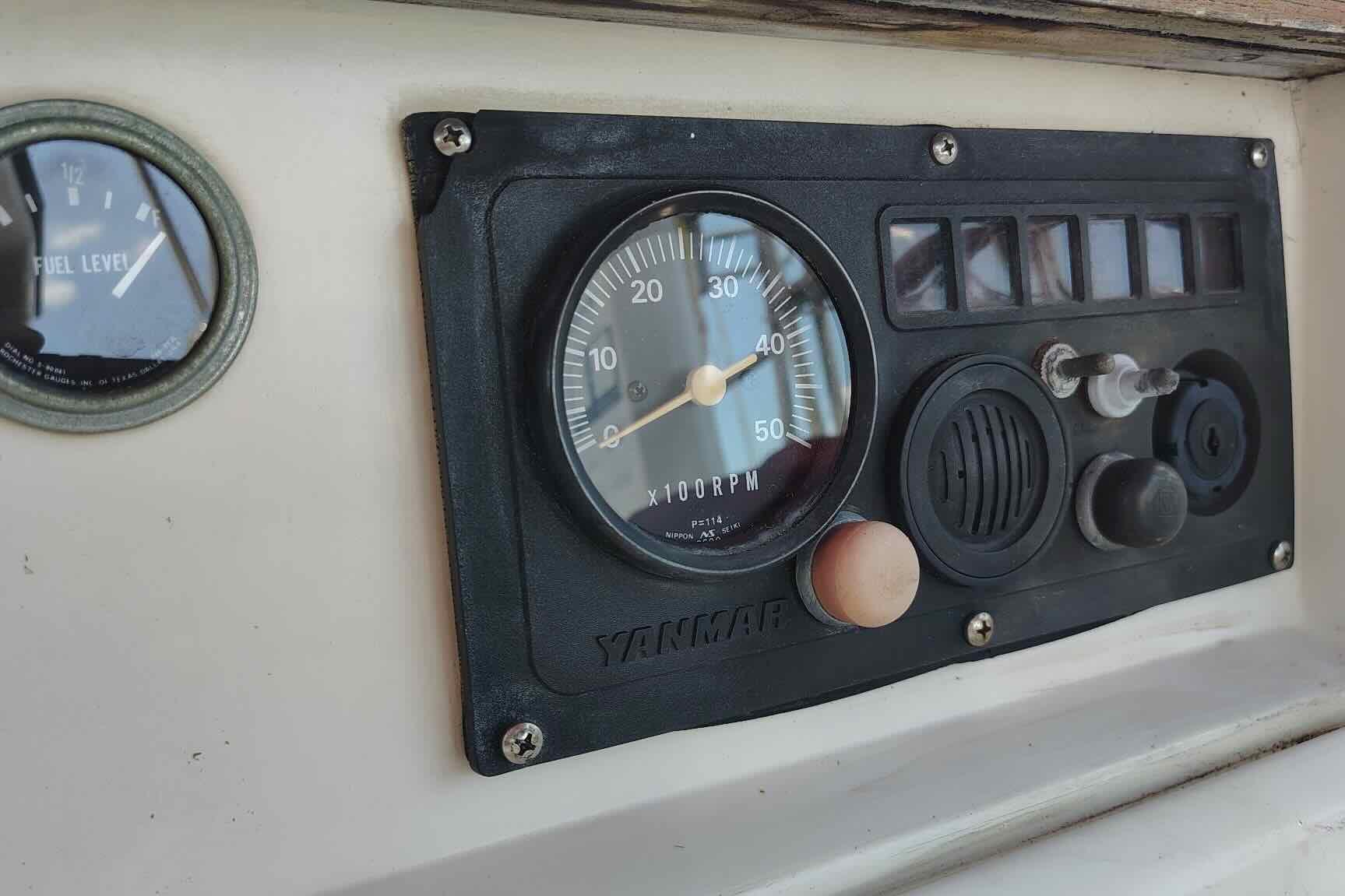 Control panel of a 1989 Island Packet 35 sailboat with Yanmar RPM gauge.