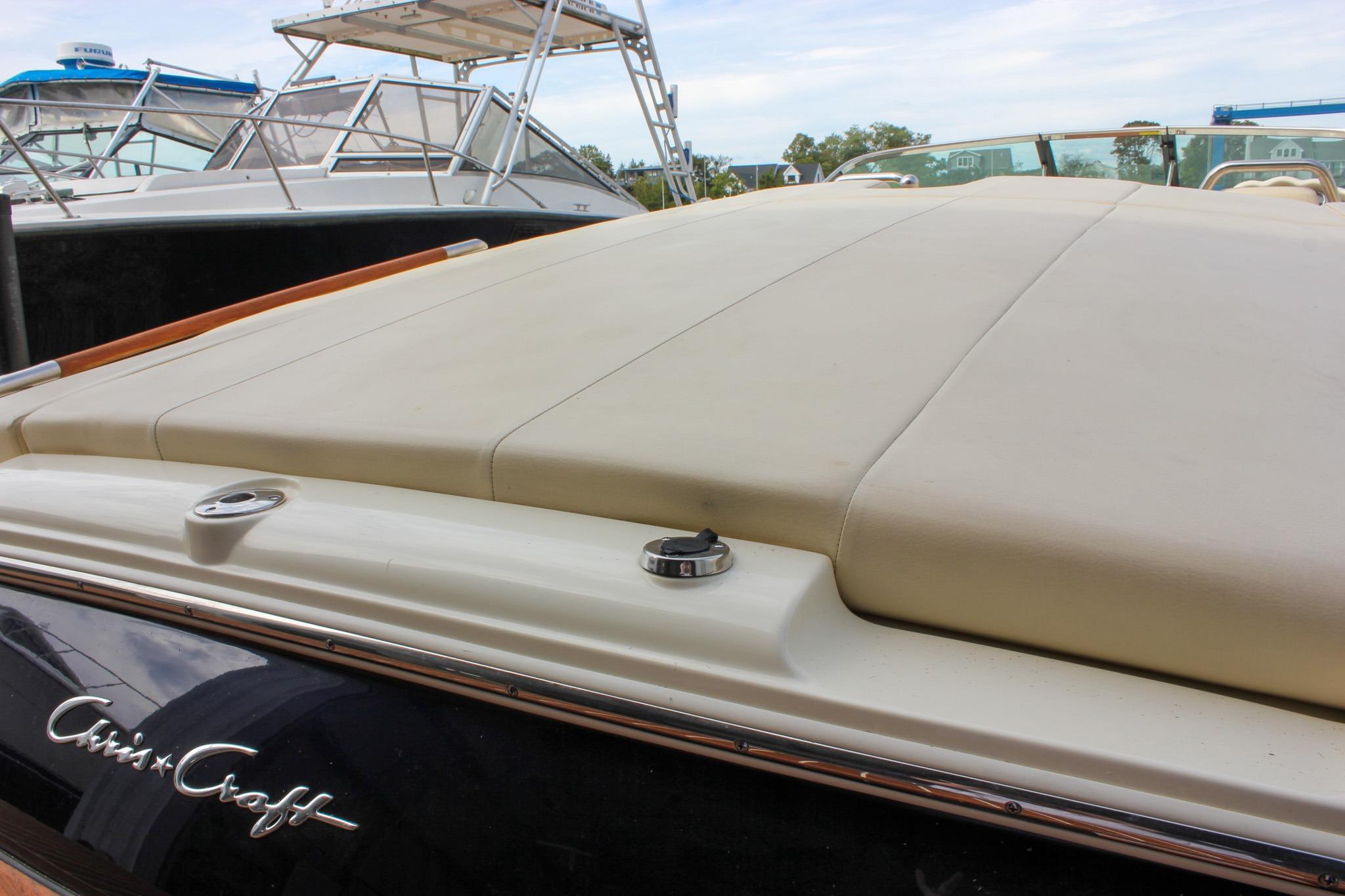 2017 Chris-Craft Capri 27 boat with beige upholstery, docked alongside other boats.
