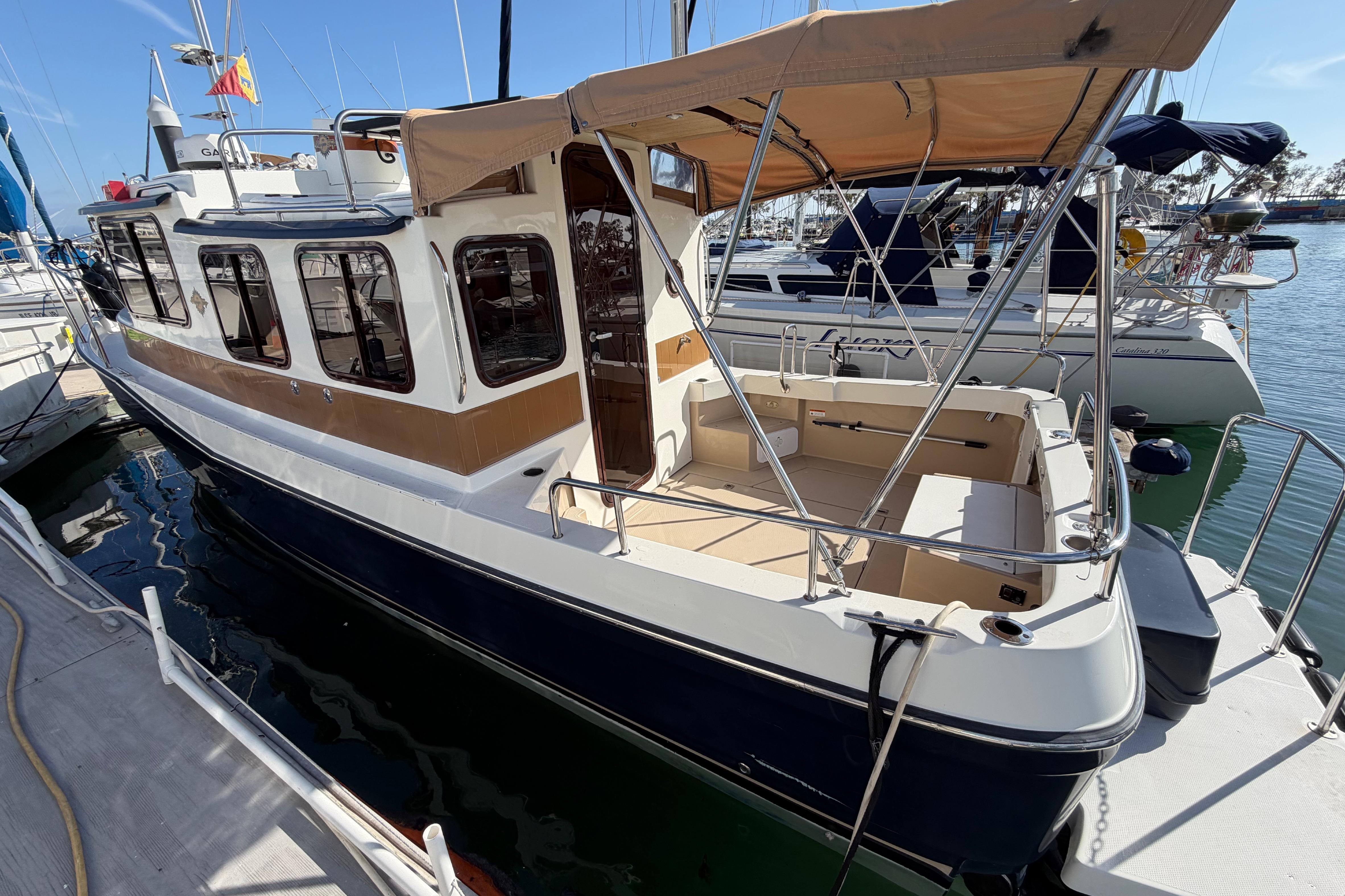 2017 Ranger Tugs R-27 boat docked, featuring a spacious deck and canopy.