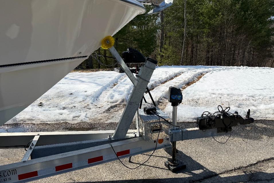 2023 Boston Whaler 250 Outrage boat on trailer in snowy landscape.