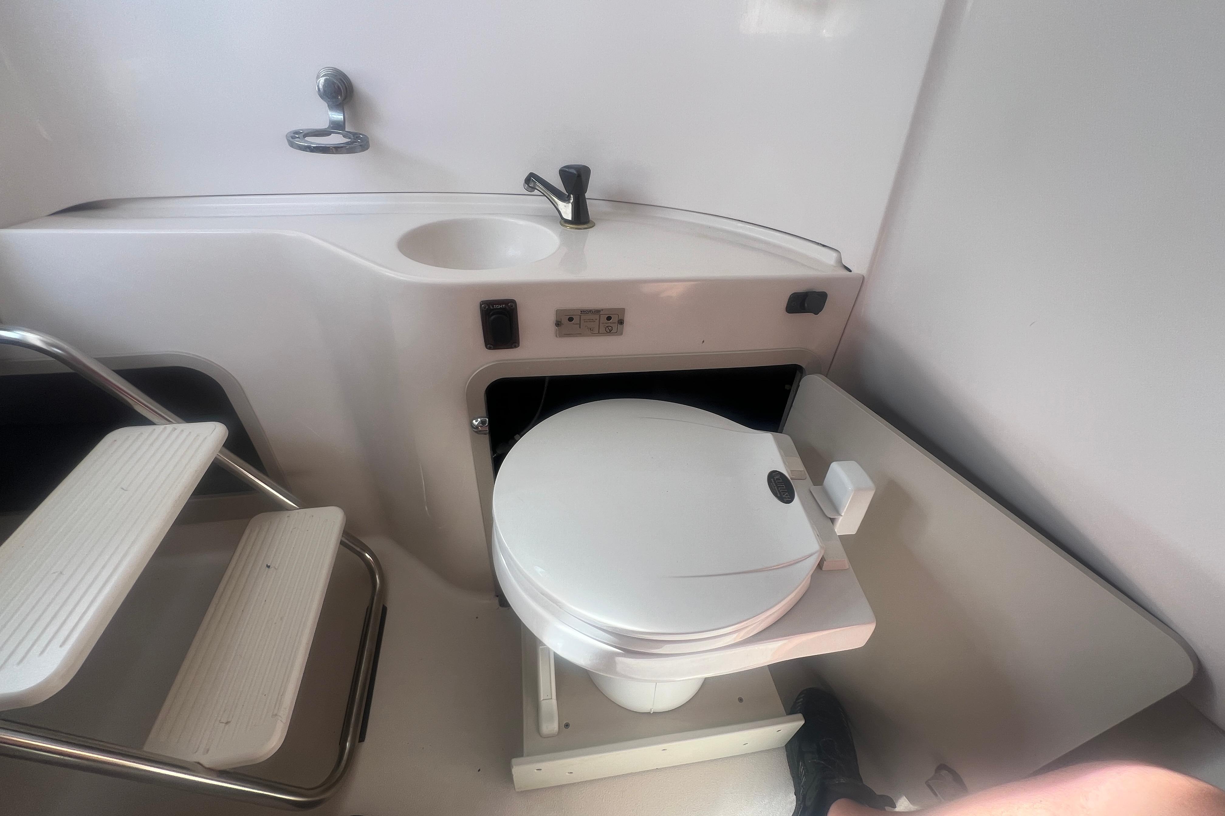 Interior of 2002 Hurricane SunDeck 260 OB boat featuring compact bathroom amenities.