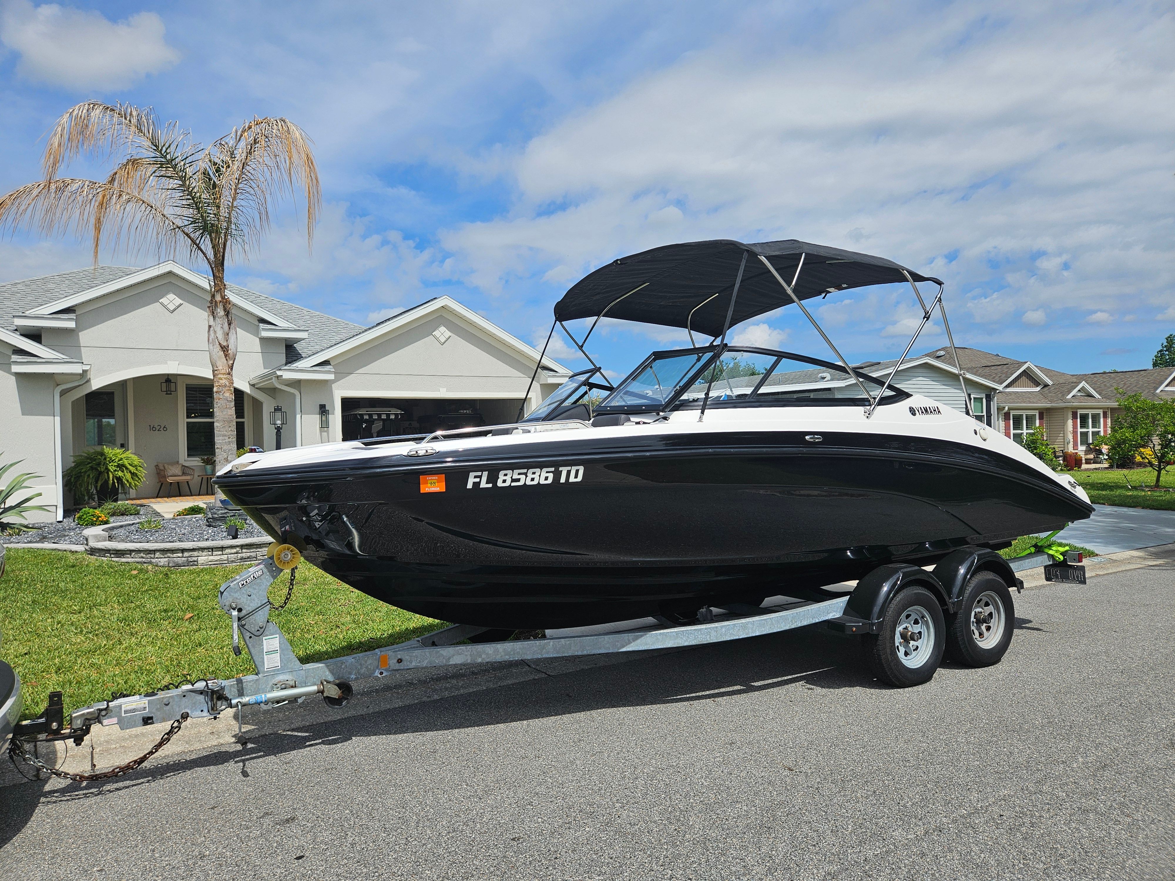 2022 Yamaha SX210 boat on trailer parked in front of house.