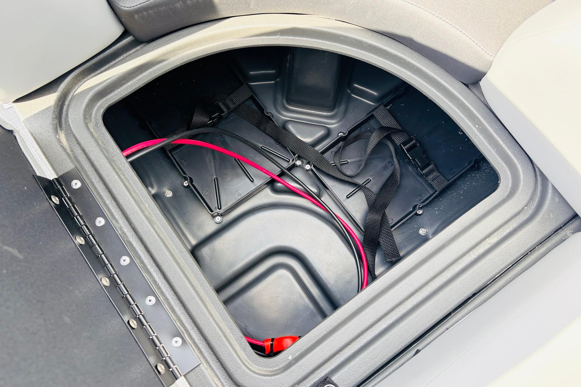 Storage compartment of 2026 Sun Tracker SportFish 22 DLX boat with cables and straps.