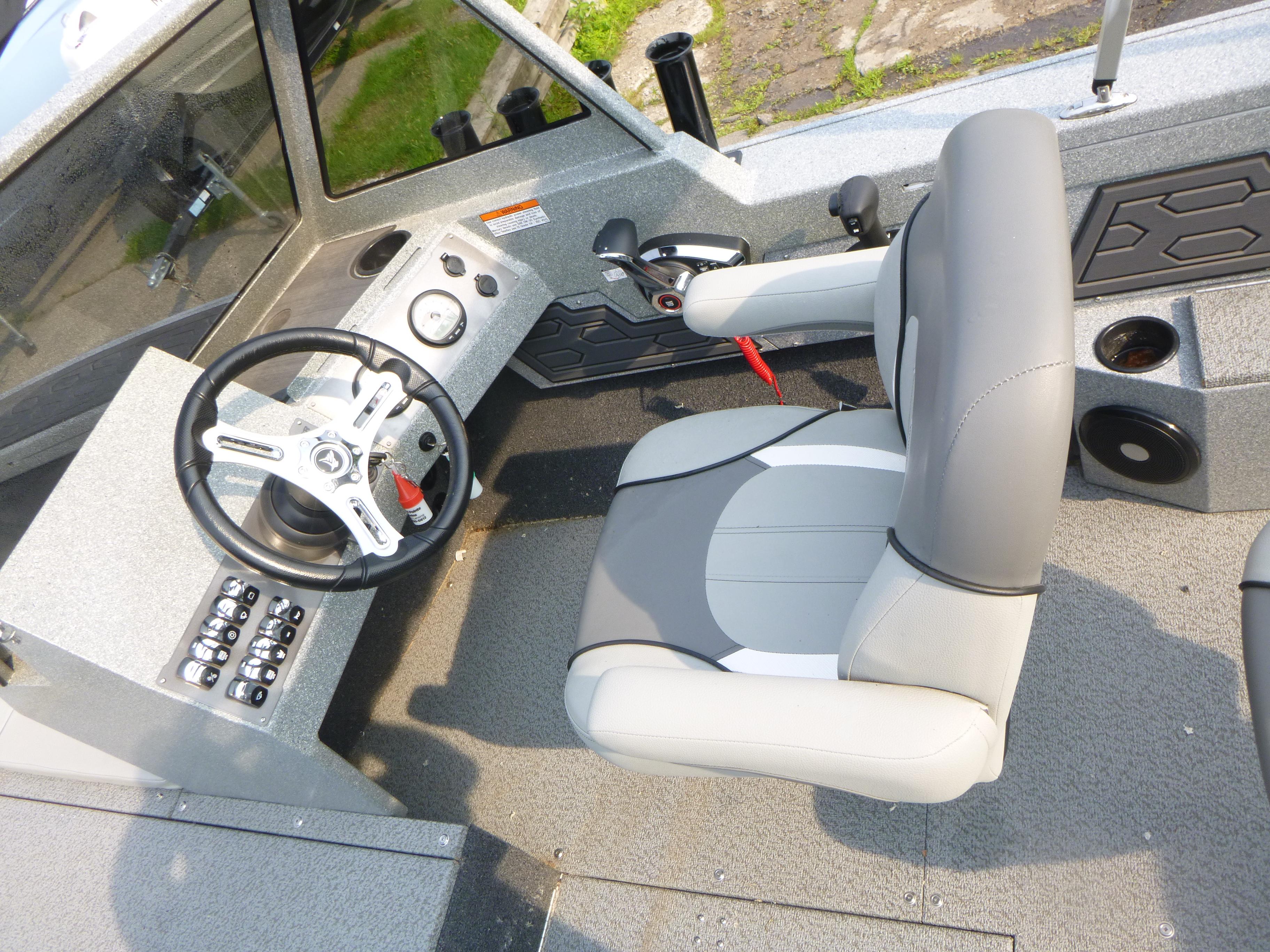 Interior of 2025 KingFisher 2125 Arrow Sport boat, featuring steering wheel and captain's chair.