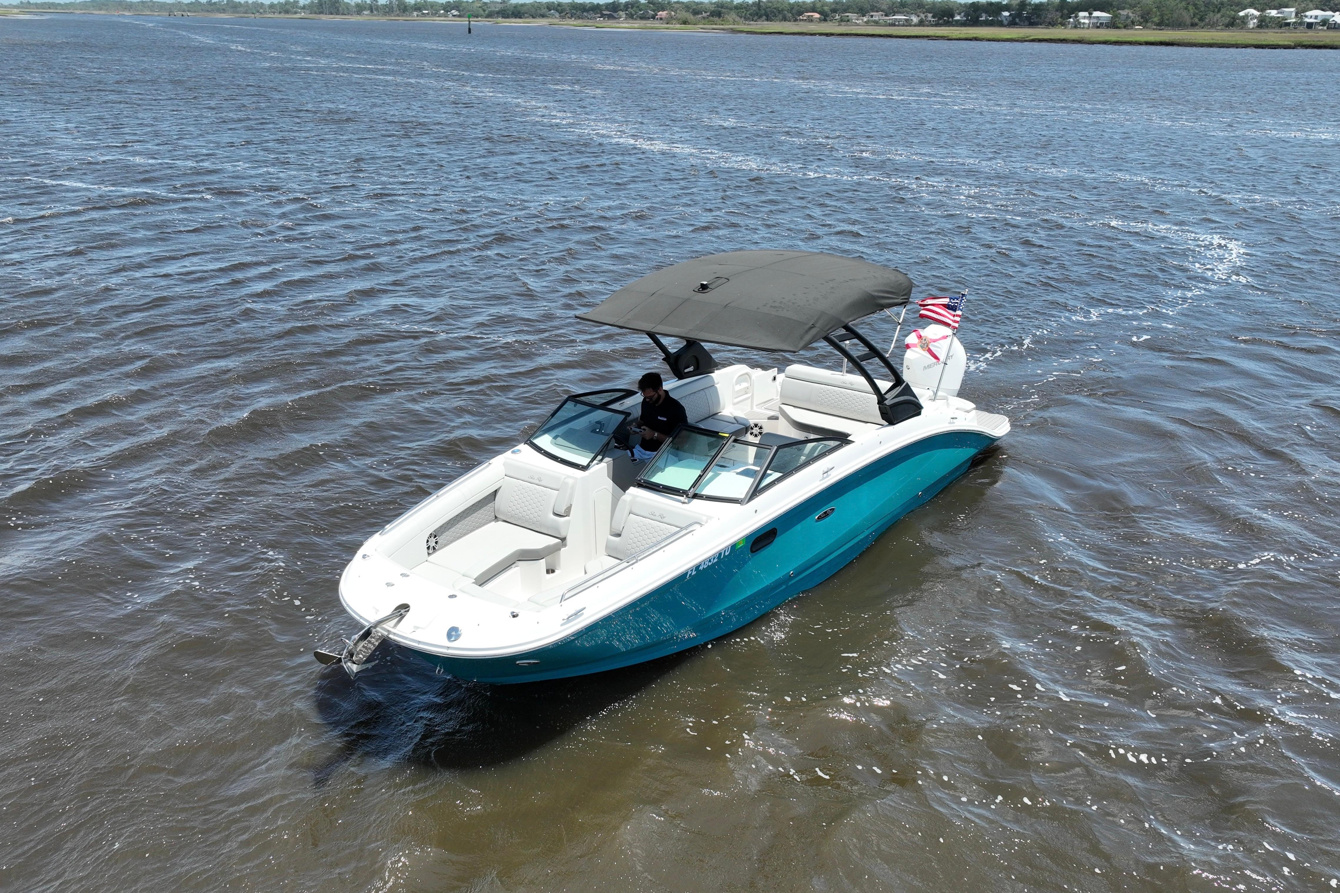 2024 Sea Ray SDX 270 Outboard boat cruising on open water with canopy and American flag.