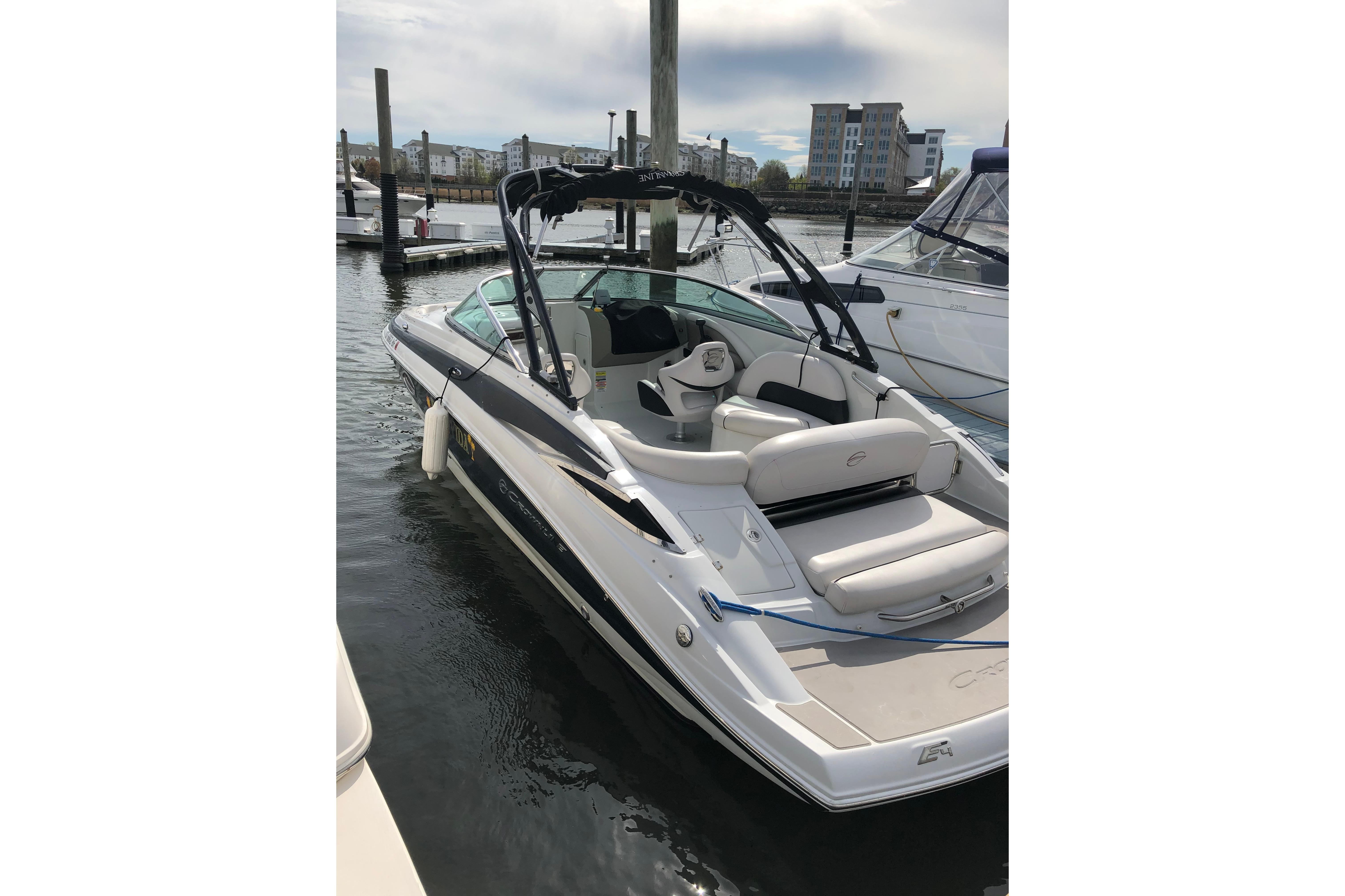 2013 Crownline Eclipse E4 boat docked in a marina, featuring sleek design and comfortable seating.