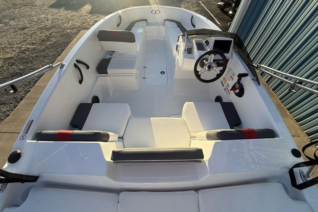 2026 Tahoe T16 boat interior with seating, steering wheel, and control panel in sunlight.